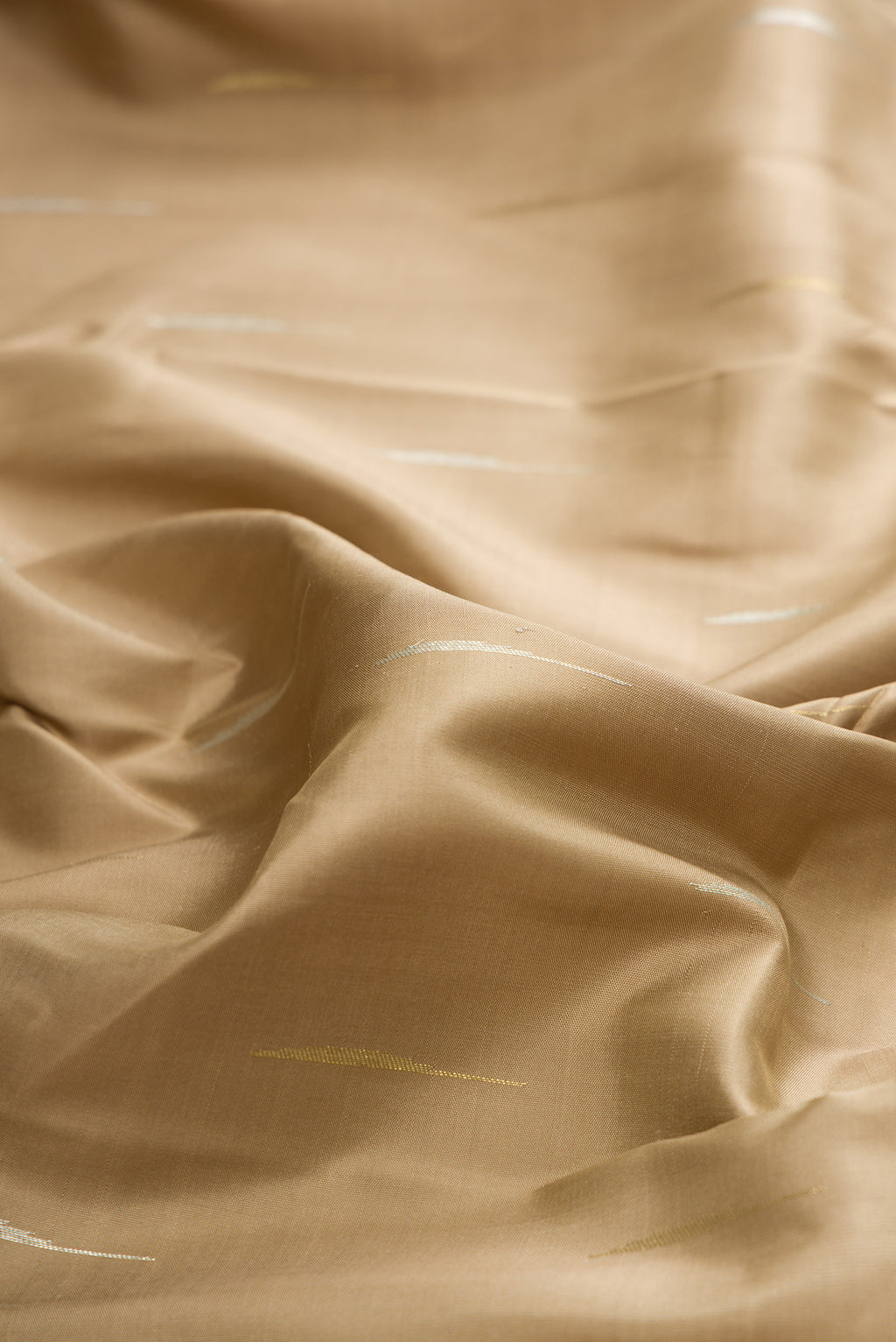 Close up of Pure Silk Pure Zari Dark Beige Kanchipuram Saree with Zari Butta on the body and Fancy Border.  displaying folds