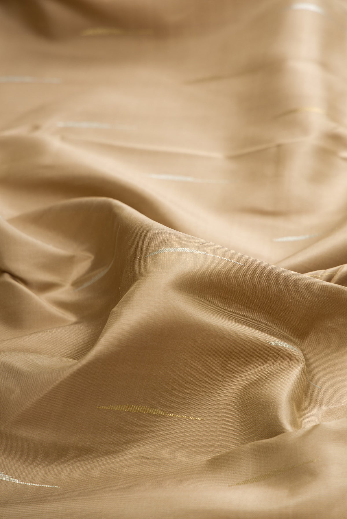 Close up of Pure Silk Pure Zari Dark Beige Kanchipuram Saree with Zari Butta on the body and Fancy Border.  displaying folds