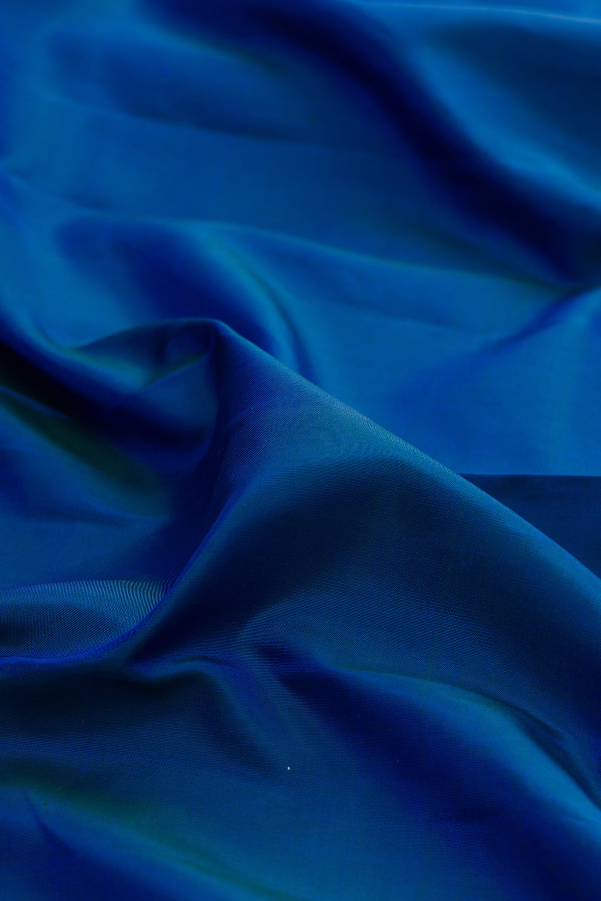 Close up of Pure Silk Blue Kanchipuram Saree with Plain Body and Zari Border.  displaying folds