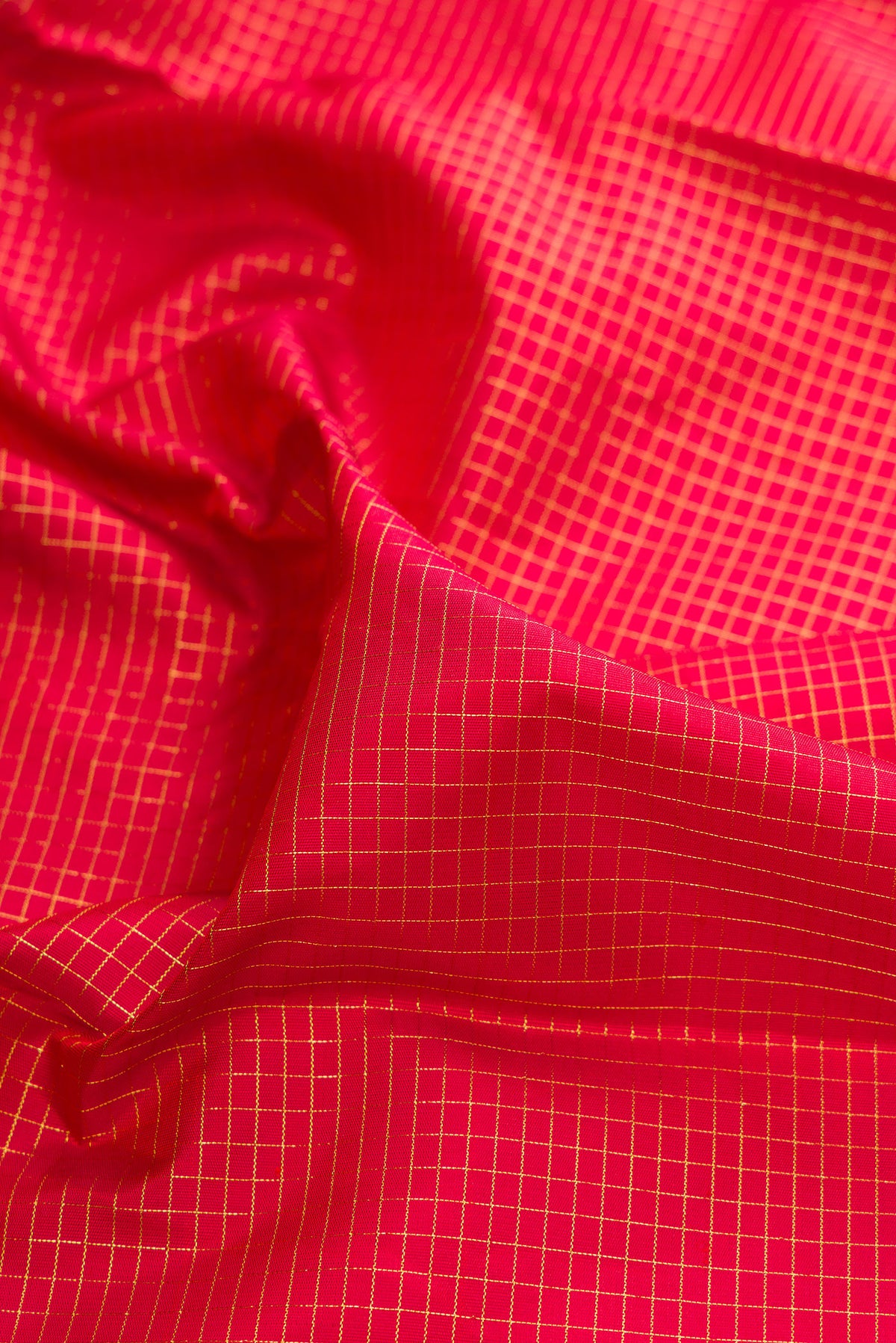 Close up of Pure Silk Red Kanjivaram Saree with Checked design on the body and Temple Border.  displaying folds