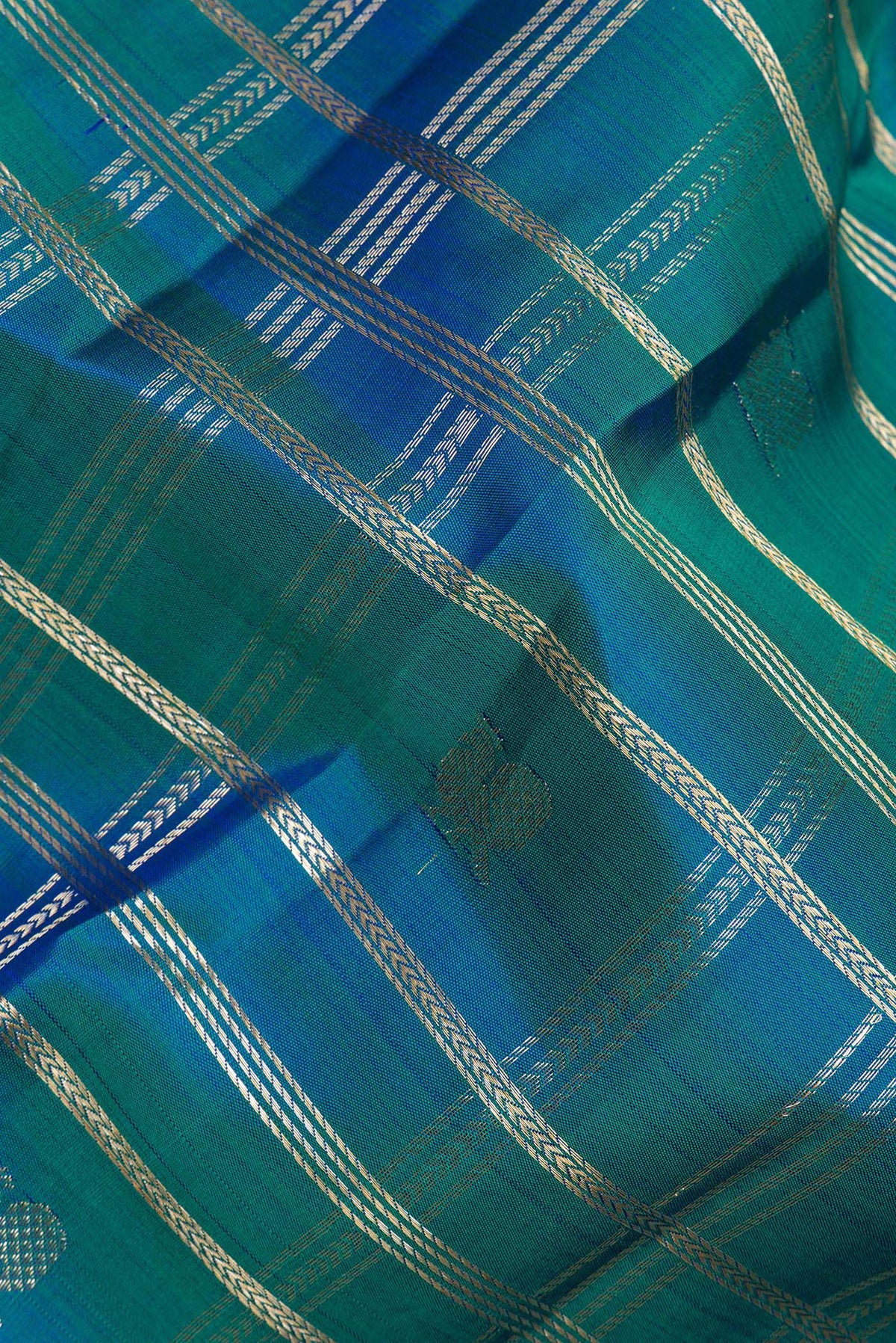 Close up of Pure Silk Peacock Blue Dual Tone Kanchipuram Saree with Checked design on the body and Zari Border.  displaying folds