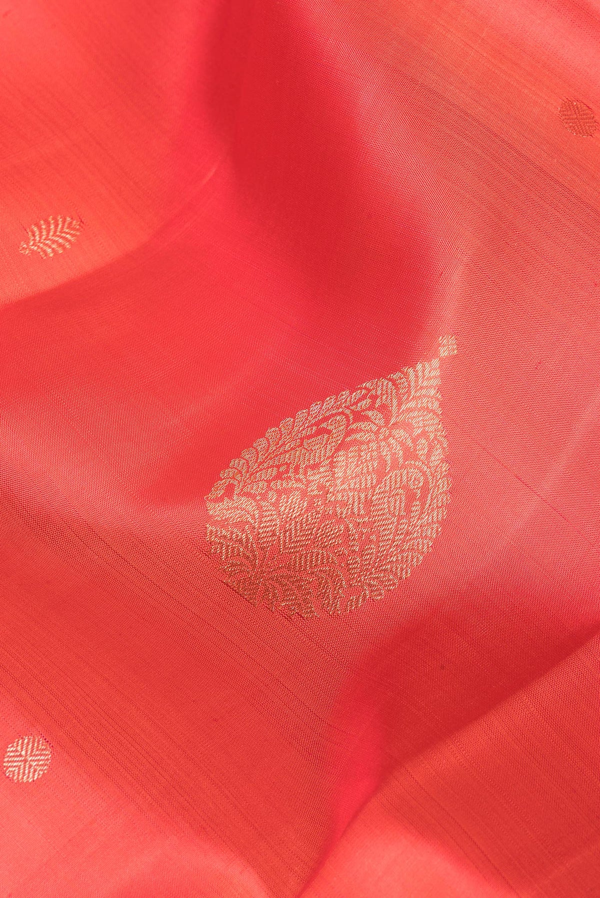 Close up of Pure Silk Orange Dual Tone Kanjivaram Saree with Zari Butta on the body and Zari Border.  displaying folds