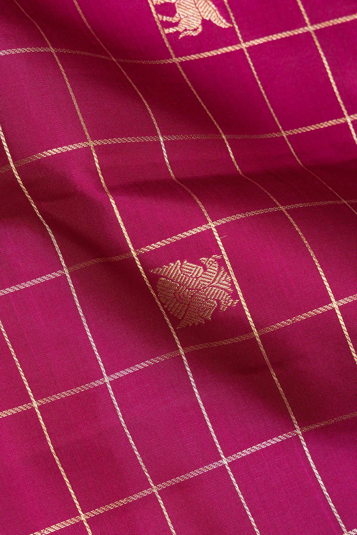 Close up of Pure Silk Magenta Dual Tone Kanchipuram Saree with Checked design on the body and Zari Border.  displaying folds