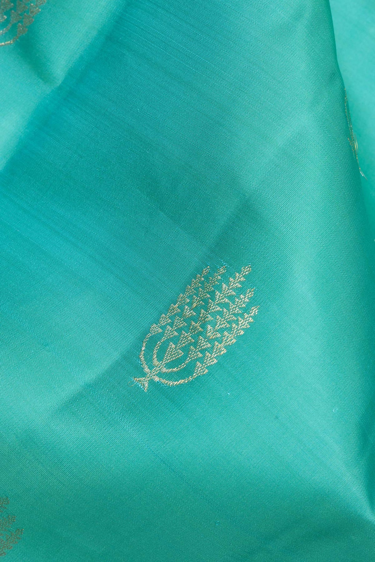Close up of Pure Silk Turquoise Kanjivaram Saree with Zari Butta on the body and Zari Border.  displaying folds