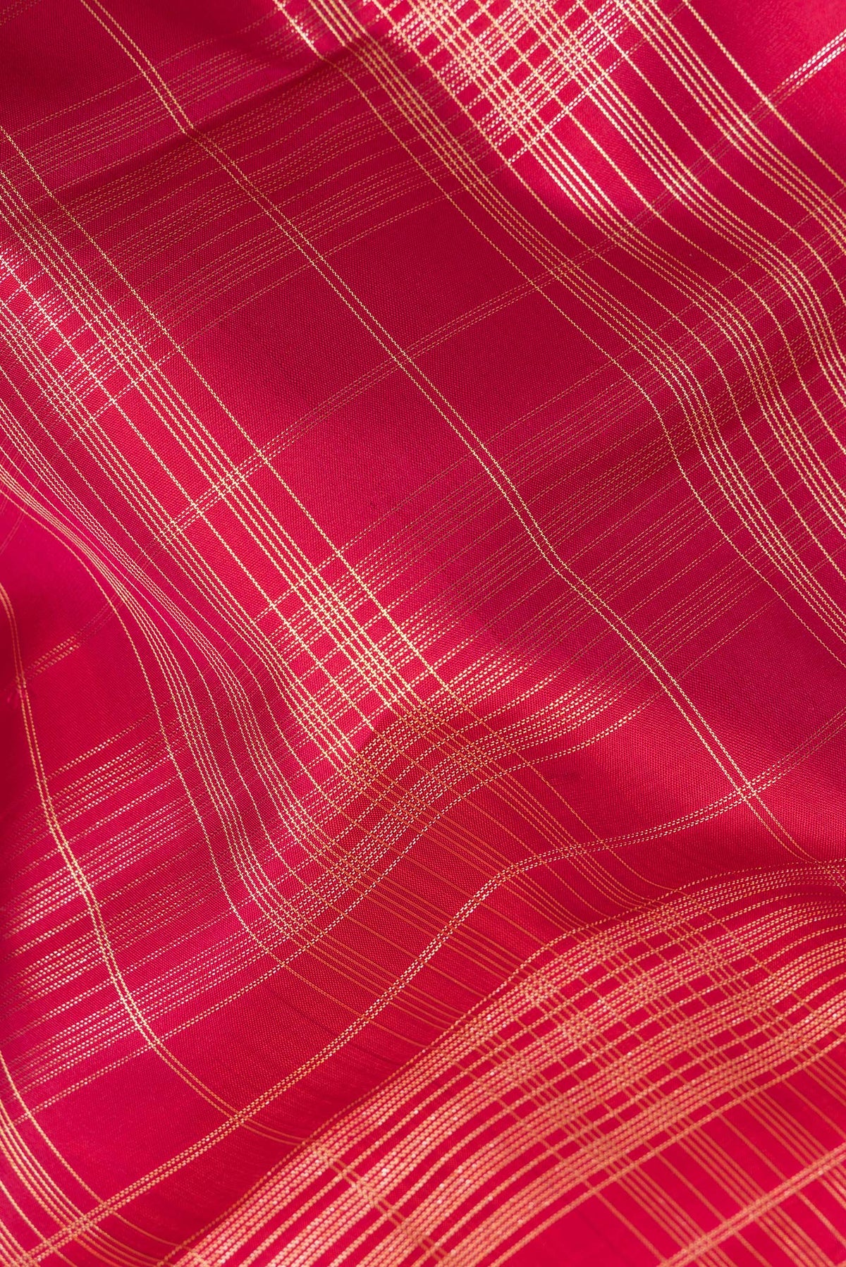 Close up of Pure Silk Deep Red Kanchipuram Saree with Checked design on the body and Zari Border.  displaying folds