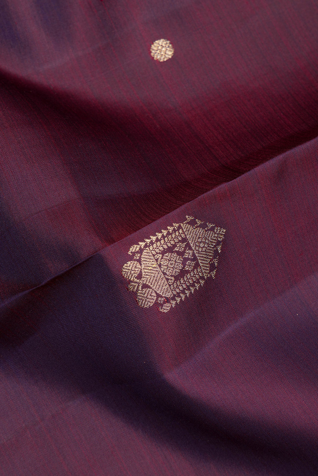 Close up of Pure Silk Burgundy Dual Tone Kanjivaram Saree with Zari Butta on the body and Zari Border.  displaying folds