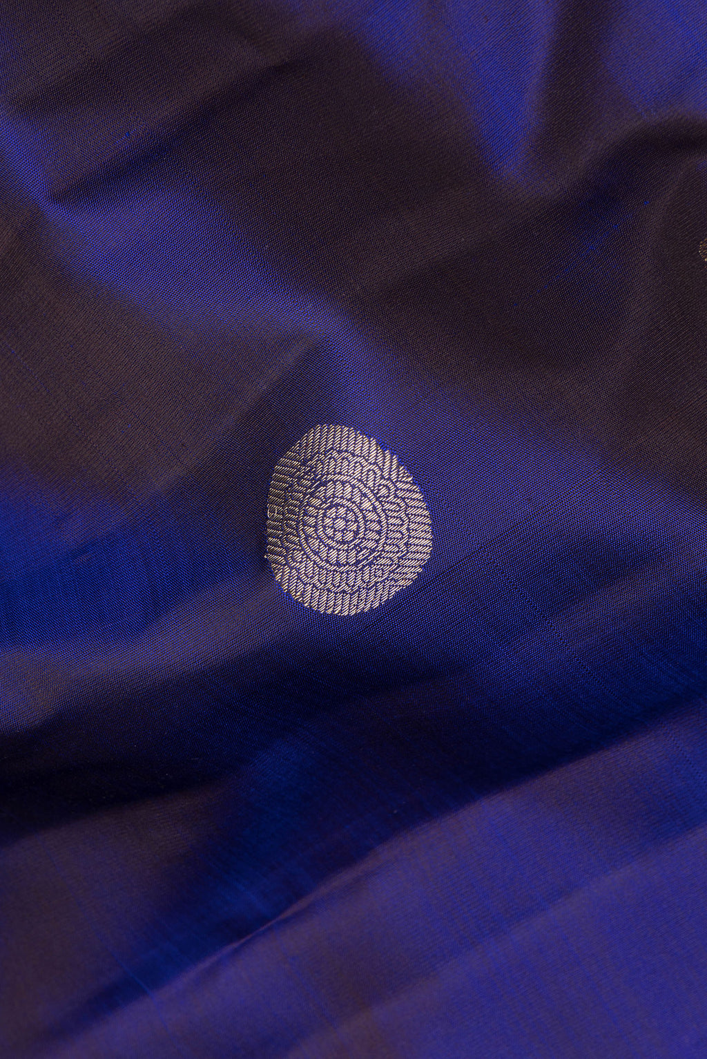 Close up of Pure Silk Navy Blue Dual Tone Kanchipuram Saree with Zari Butta on the body and Zari Border.  displaying folds