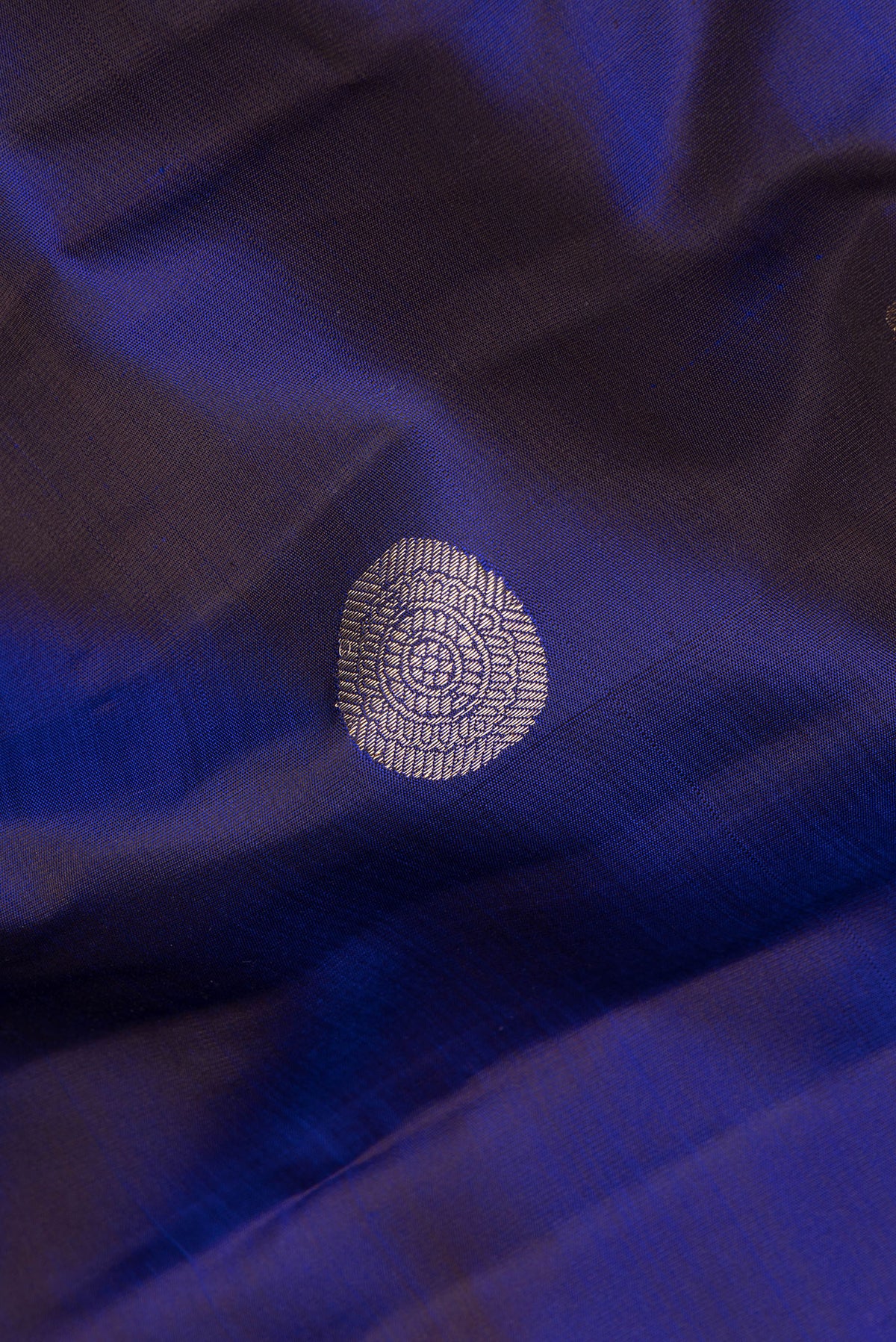 Close up of Pure Silk Navy Blue Dual Tone Kanchipuram Saree with Zari Butta on the body and Zari Border.  displaying folds