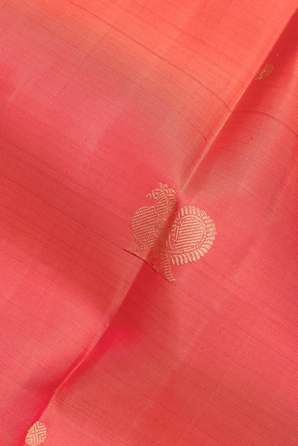 Close up of Pure Silk Brick Orange Kanchipuram Saree with Zari Butta on the body and Zari Border.  displaying folds