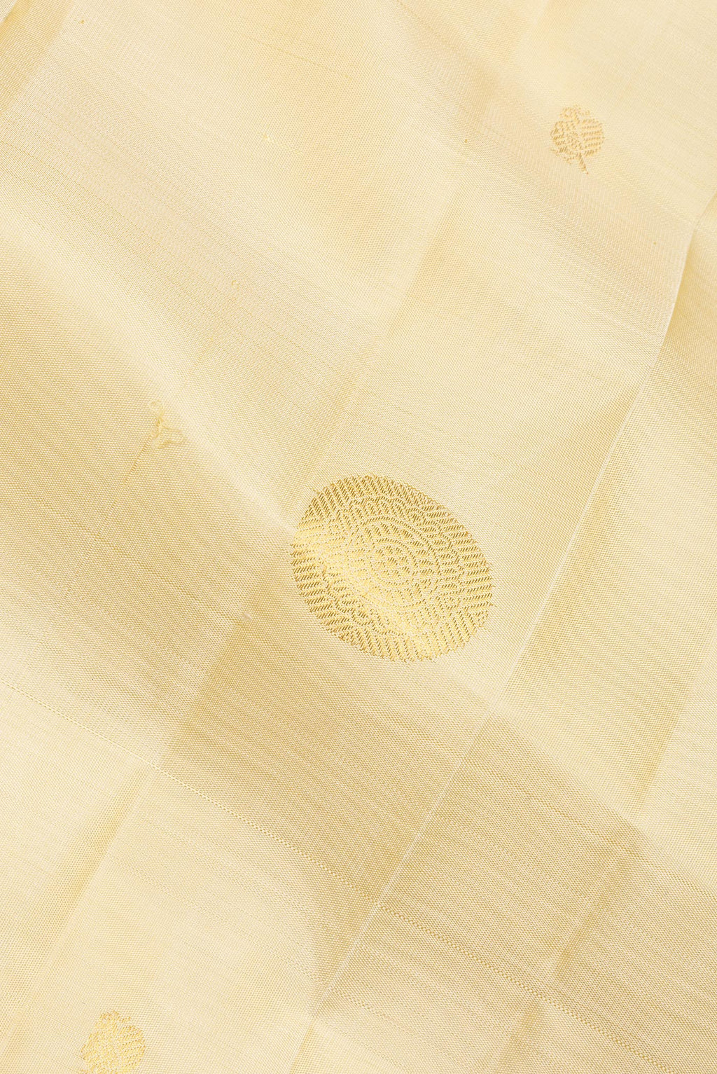 Close up of Pure Silk Cream Kanchipuram Saree with Zari Butta on the body and Zari Border.  displaying folds
