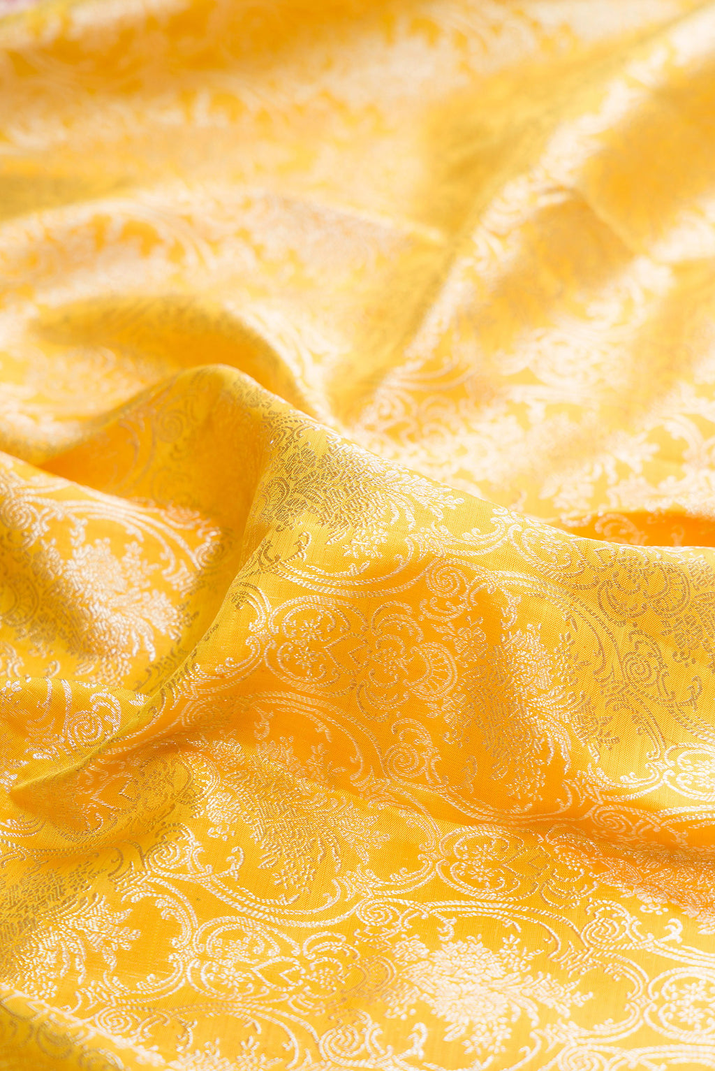 Close up of Pure Silk Lemon Yellow Kanjivaram Saree with Zari Brocade on the body and Zari Border.  displaying folds