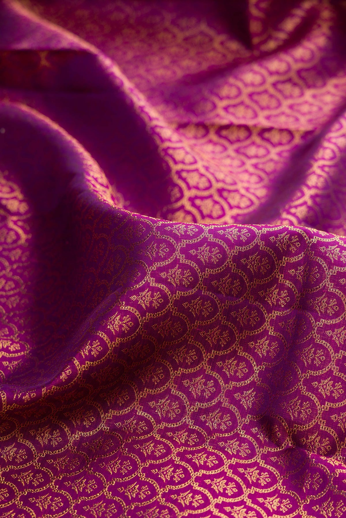 Close up of Pure Silk Magenta Kanchipuram Saree with Zari Brocade on the body and Zari Border.  displaying folds