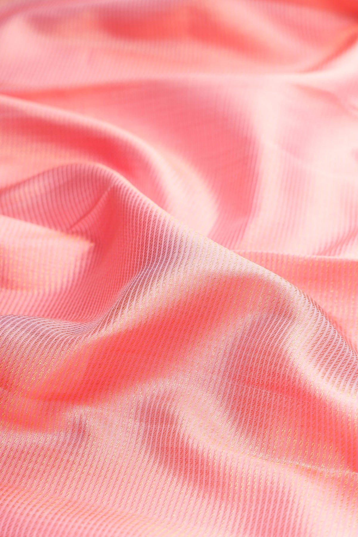 Close up of Pure Silk Peach Kanchipuram Saree with Zari Brocade on the body and Zari Border.  displaying folds