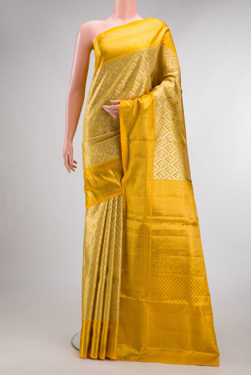 Yellow Dual Tone Kanjivaram Tissue Saree with Zari Brocade on the body and Zari Border.  displayed on a mannequin