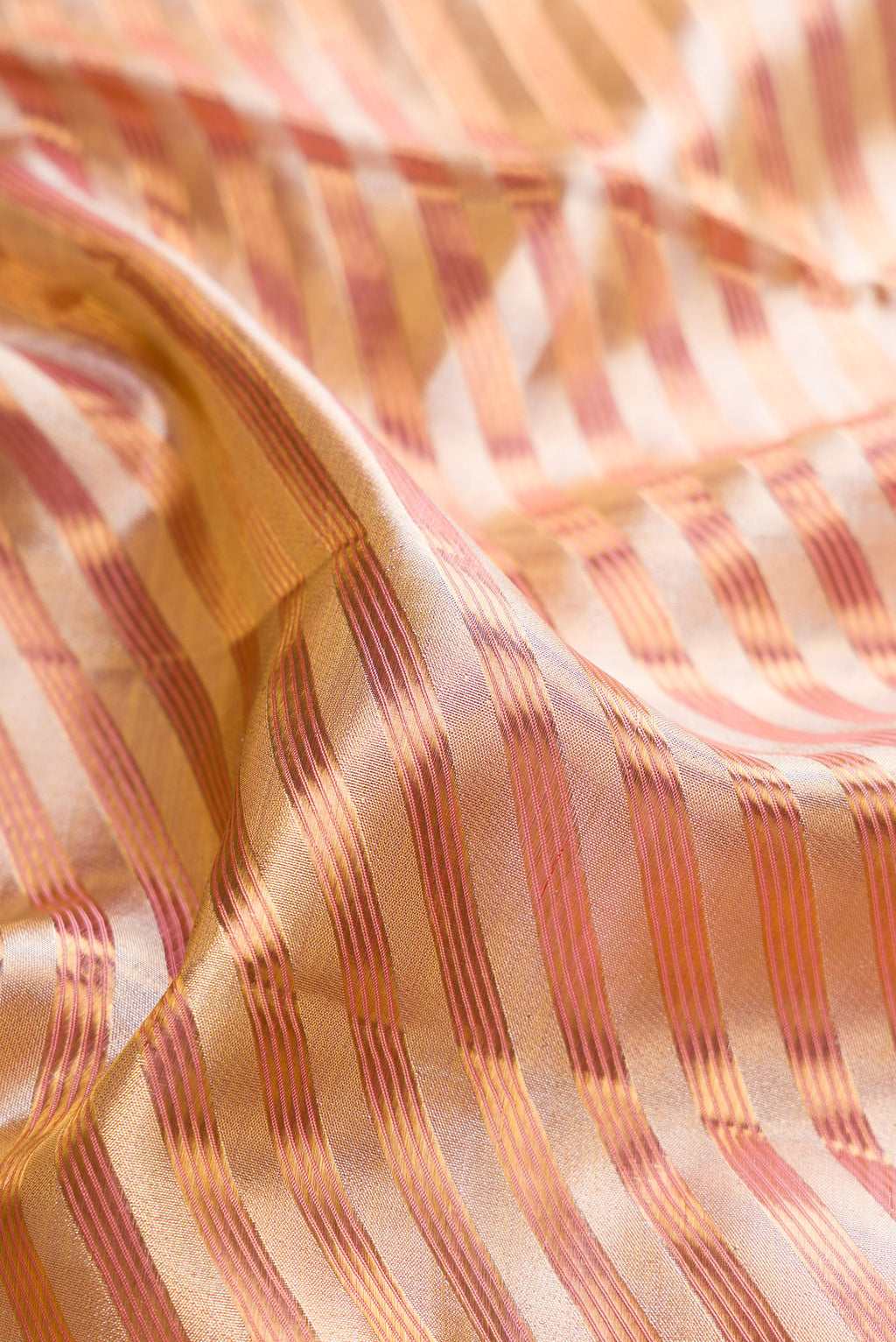 Close up of Gold Dual Tone Kanjivaram Tissue Saree with Zari Brocade on the body and Fancy Border.  displaying folds