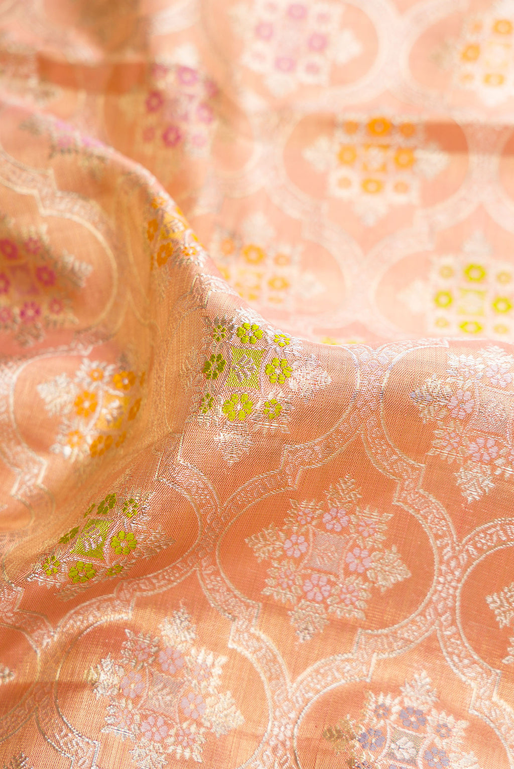 Close up of Golden Peach Dual Tone Kanjivaram Tissue Saree with Zari Brocade on the body and Fancy Border.  displaying folds