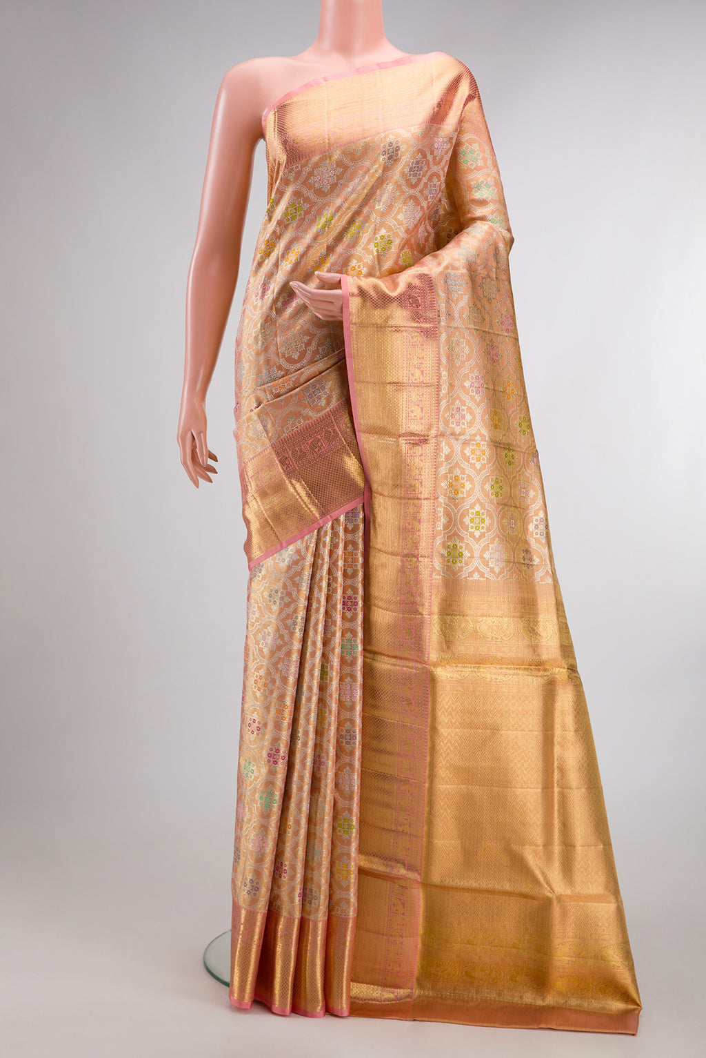 Golden Peach Dual Tone Kanjivaram Tissue Saree with Zari Brocade on the body and Fancy Border.  displayed on a mannequin
