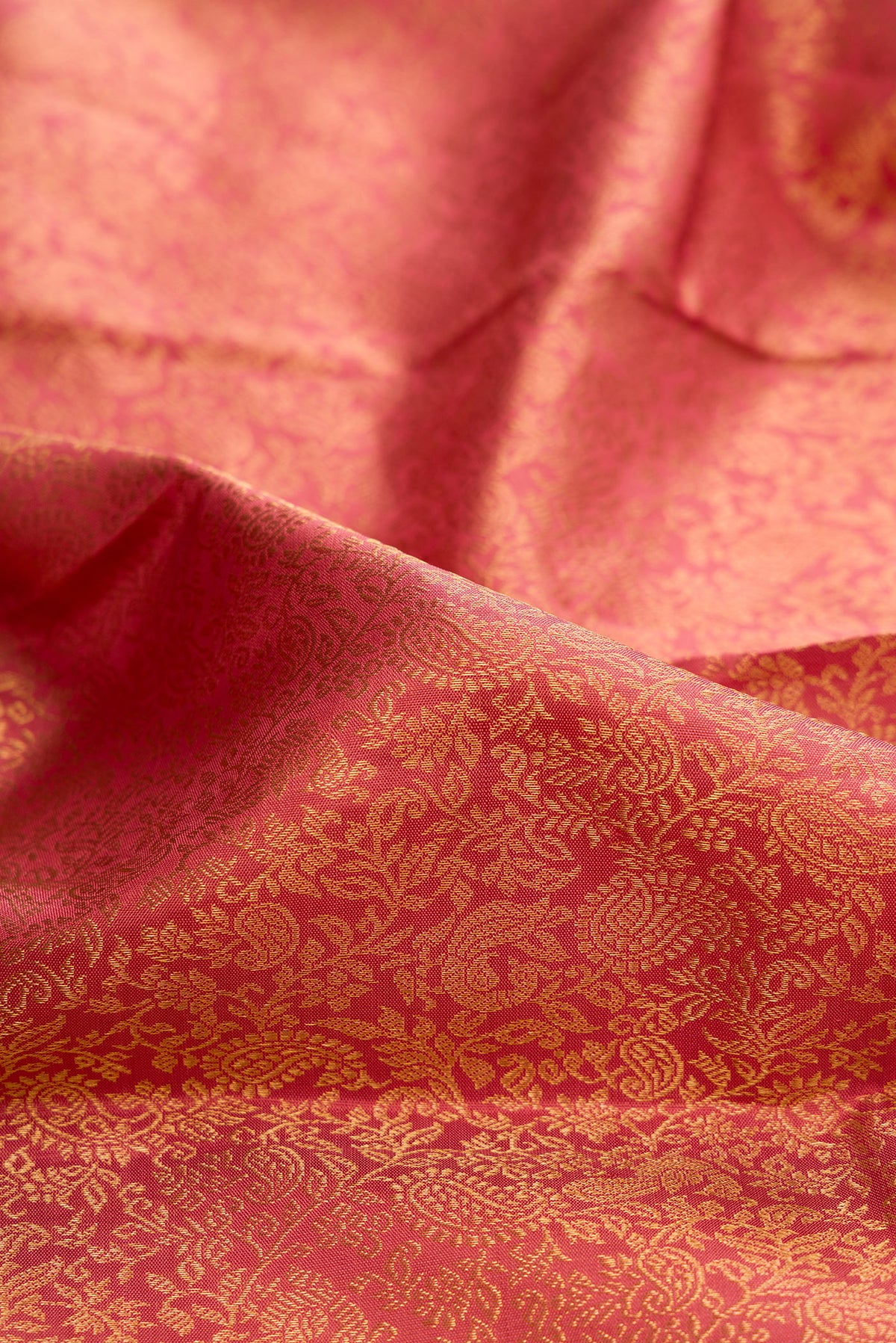 Close up of Pure Silk Peach Kanchipuram Saree with Zari Brocade on the body and Zari Border.  displaying folds