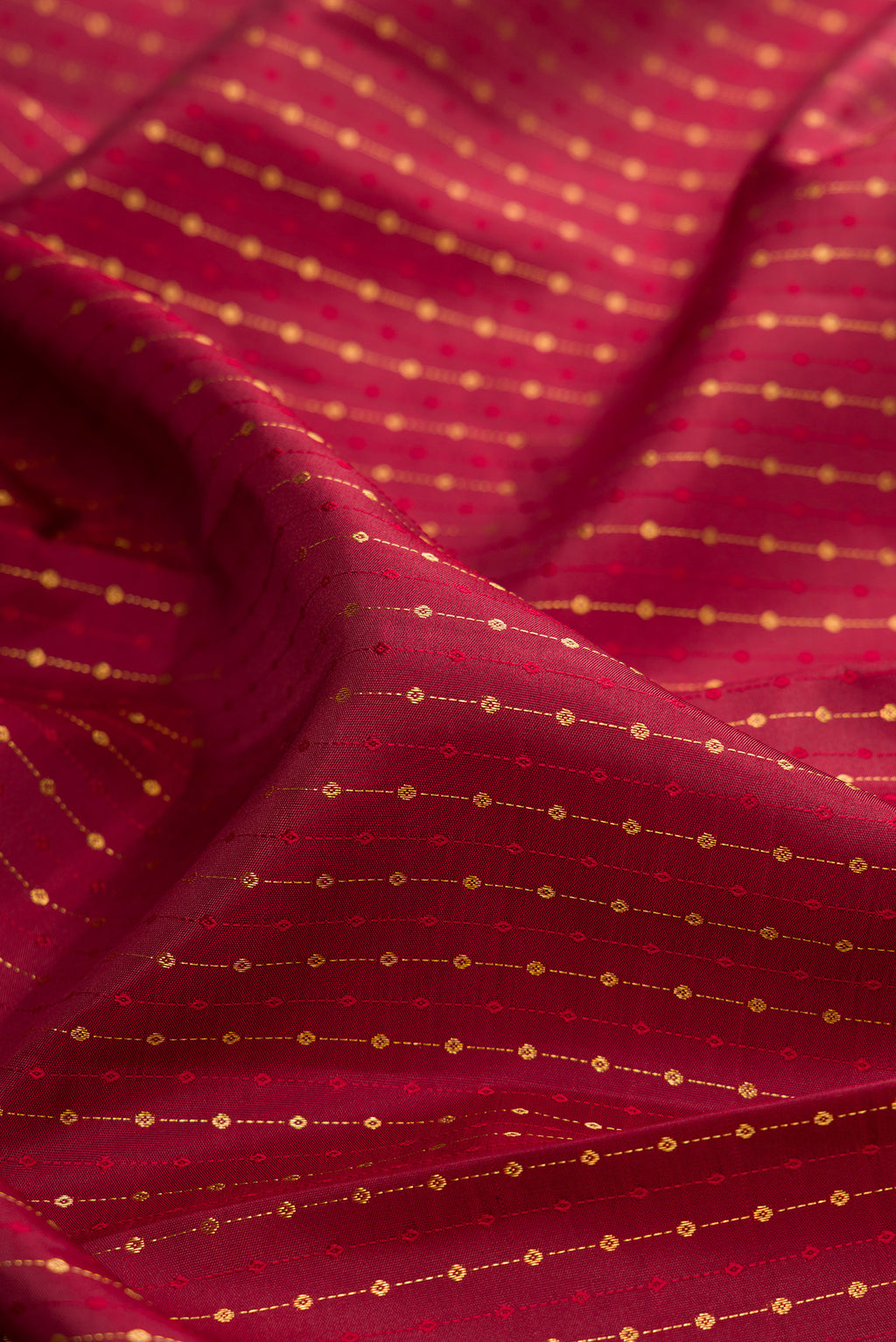 Close up of Pure Silk Maroon Kanjivaram Saree with Zari Butta on the body and Fancy Border.  displaying folds