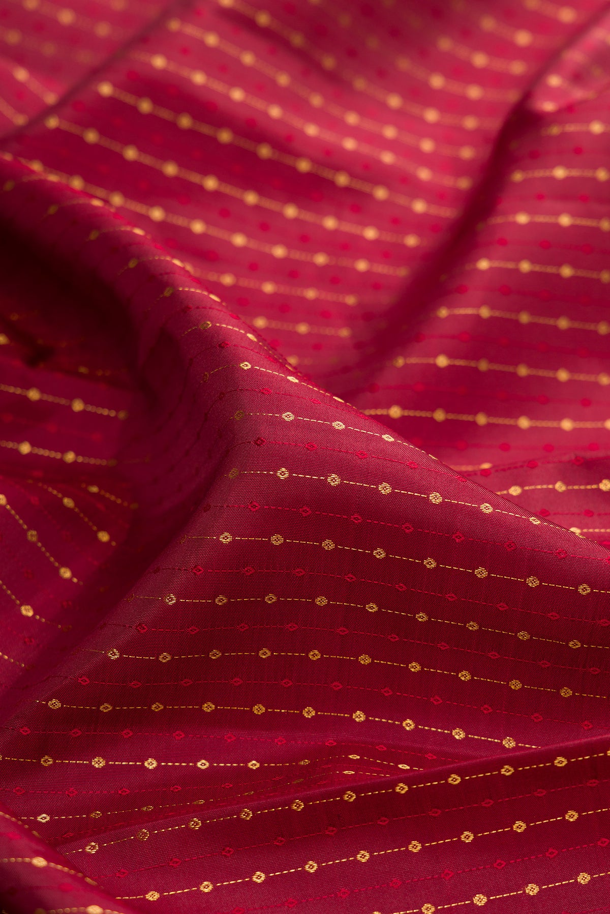 Close up of Pure Silk Maroon Kanjivaram Saree with Zari Butta on the body and Fancy Border.  displaying folds