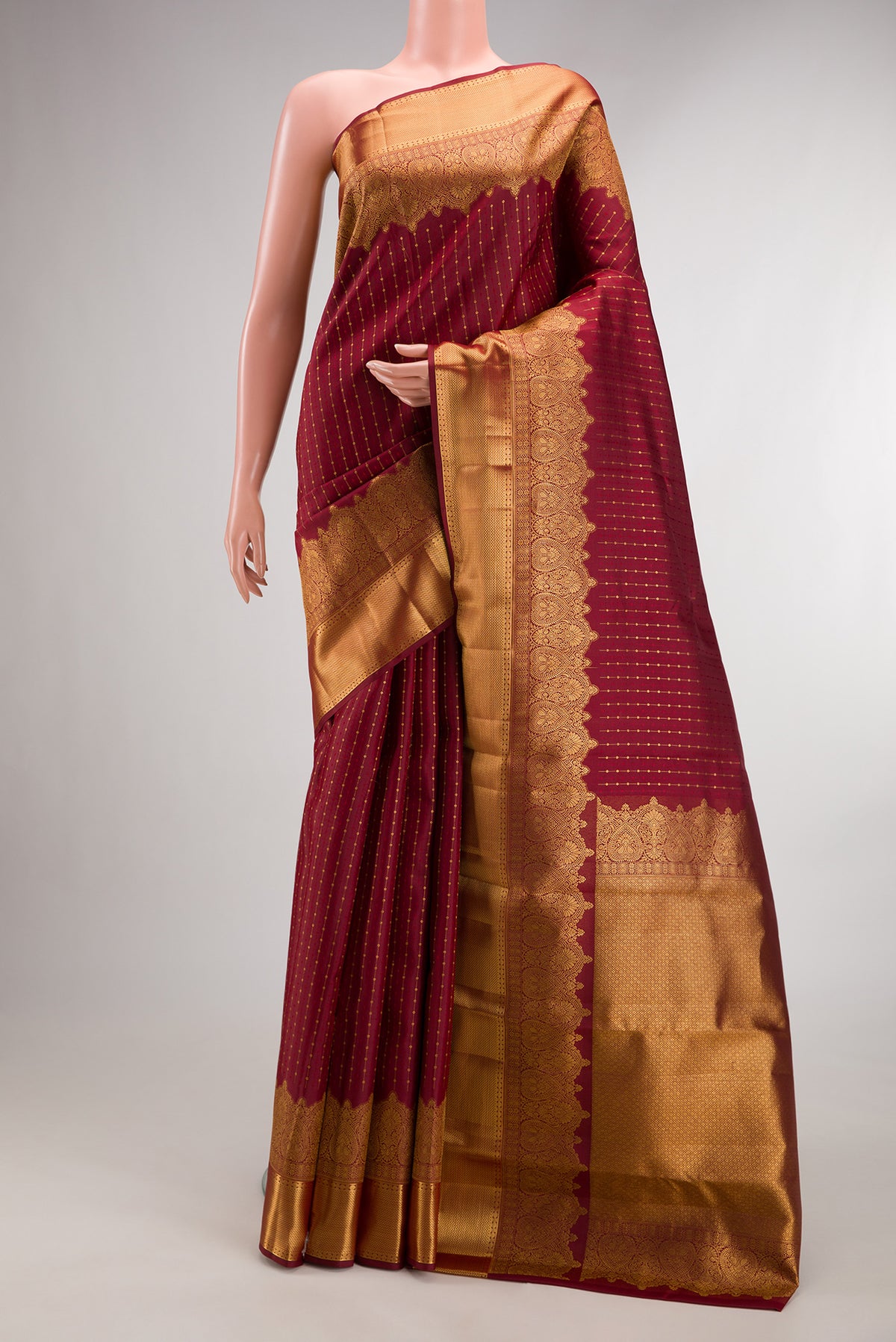Pure Silk Maroon Kanjivaram Saree with Zari Butta on the body and Fancy Border.  displayed on a mannequin