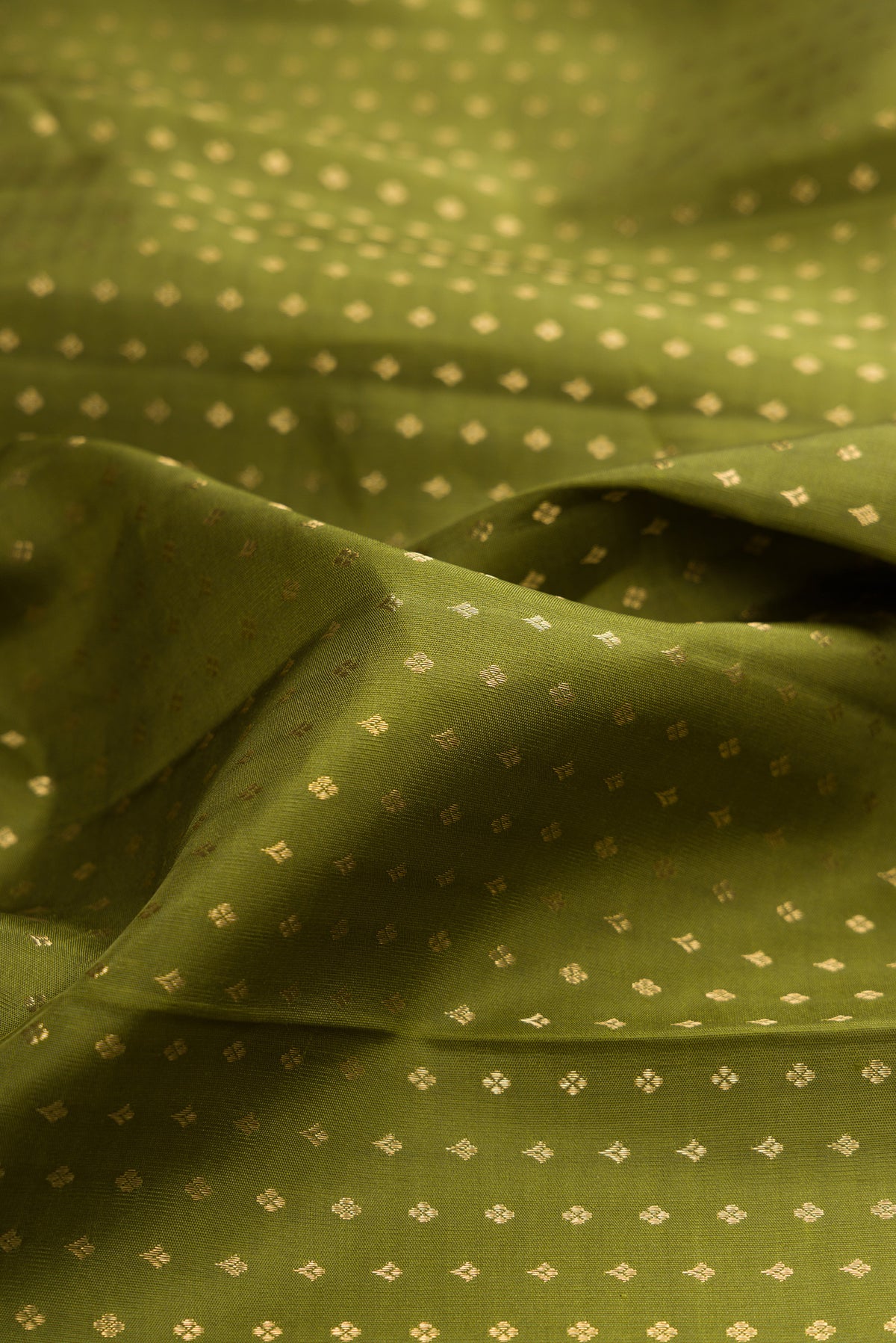 Close up of Pure Silk Mehandi Green Kanjivaram Saree with Zari Butta on the body and Zari Border.  displaying folds