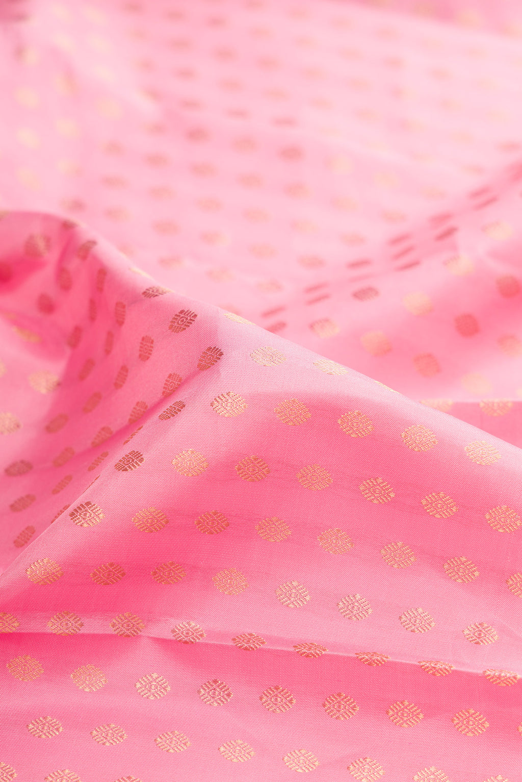 Close up of Pure Silk Rose pink Kanjivaram Saree with Zari Butta on the body and Zari Border.  displaying folds