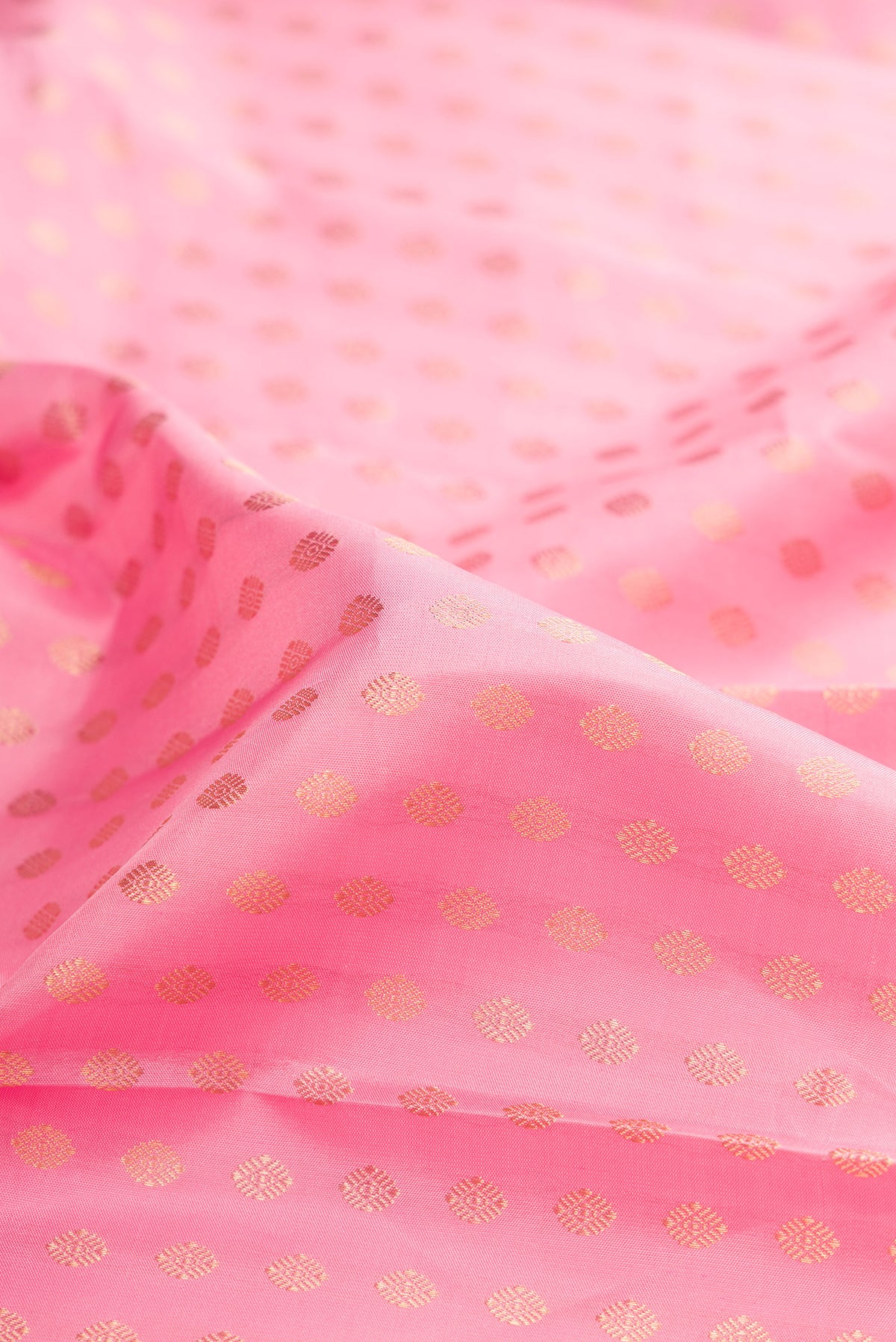Close up of Pure Silk Rose pink Kanjivaram Saree with Zari Butta on the body and Zari Border.  displaying folds
