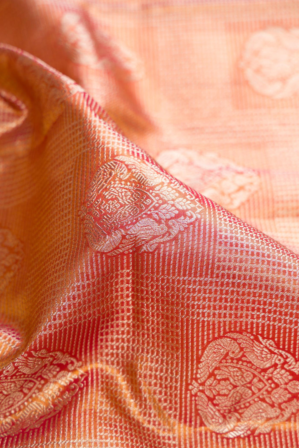 Close up of Red Dual Tone Kanjivaram Tissue Saree with Zari Brocade on the body and Fancy Border.  displaying folds