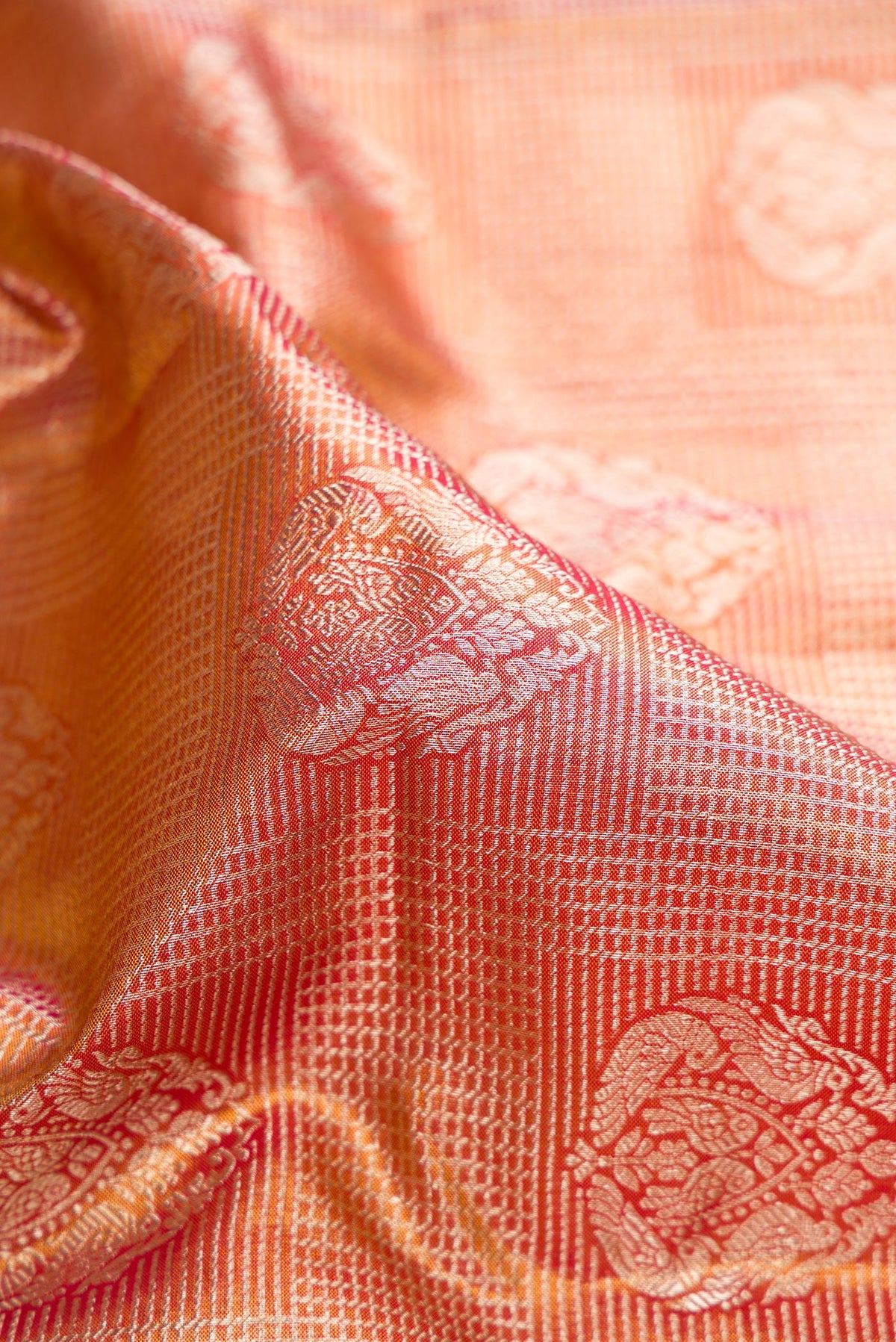 Close up of Red Dual Tone Kanjivaram Tissue Saree with Zari Brocade on the body and Fancy Border.  displaying folds