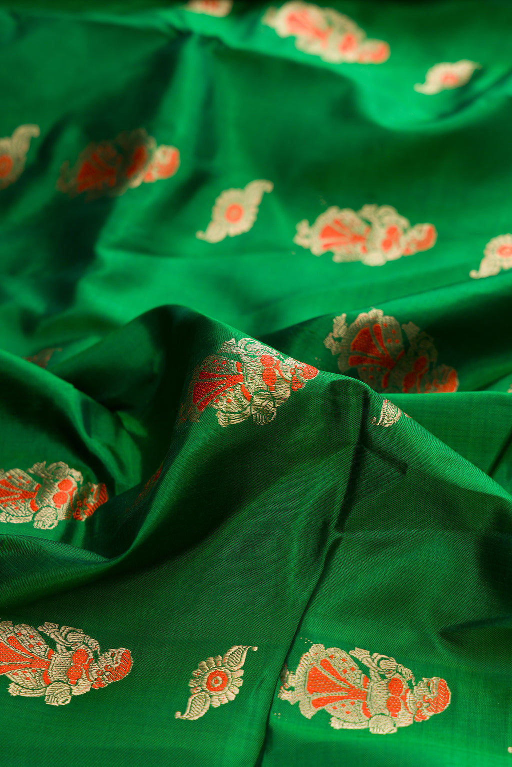 Close up of Pure Silk Green Baluchari Saree with Zari And Thread Butta on the body and Fancy Border.  displaying folds