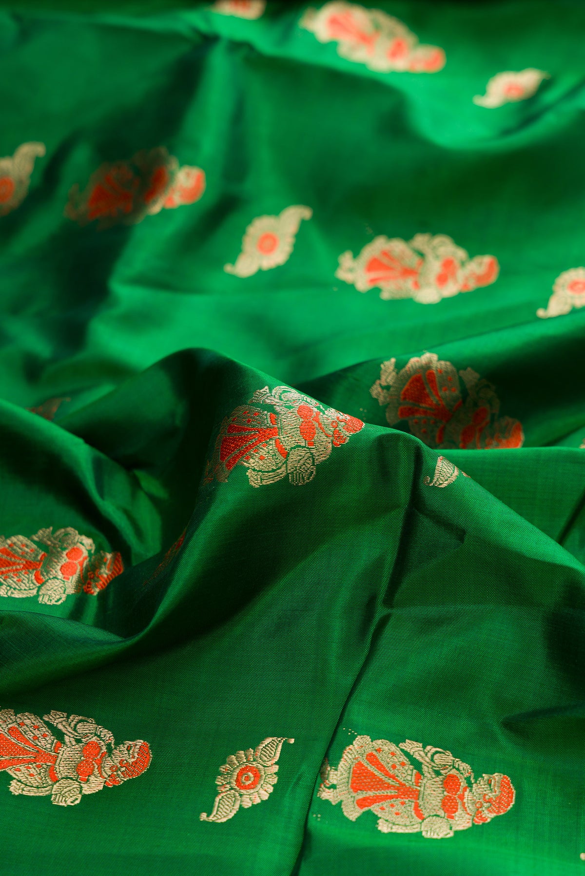 Close up of Pure Silk Green Baluchari Saree with Zari And Thread Butta on the body and Fancy Border.  displaying folds
