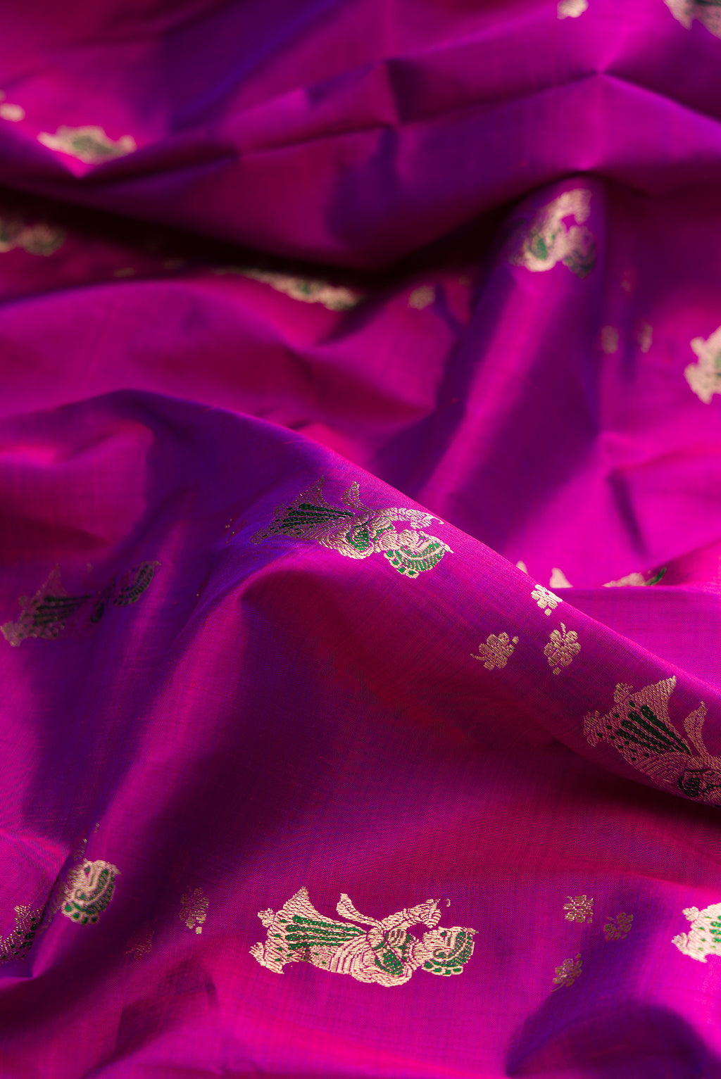 Close up of Pure Silk Magenta Baluchari Saree with Zari And Thread Butta on the body and Zari And Thread Border.  displaying folds