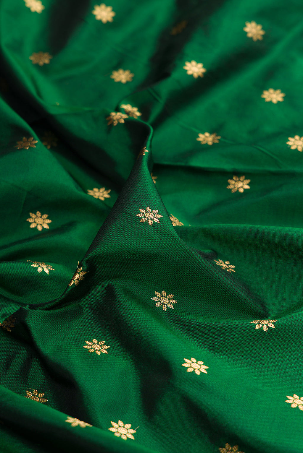 Close up of Pure Silk Bottle Green Paithani Saree with Zari Butta on the body and Zari Border.  displaying folds