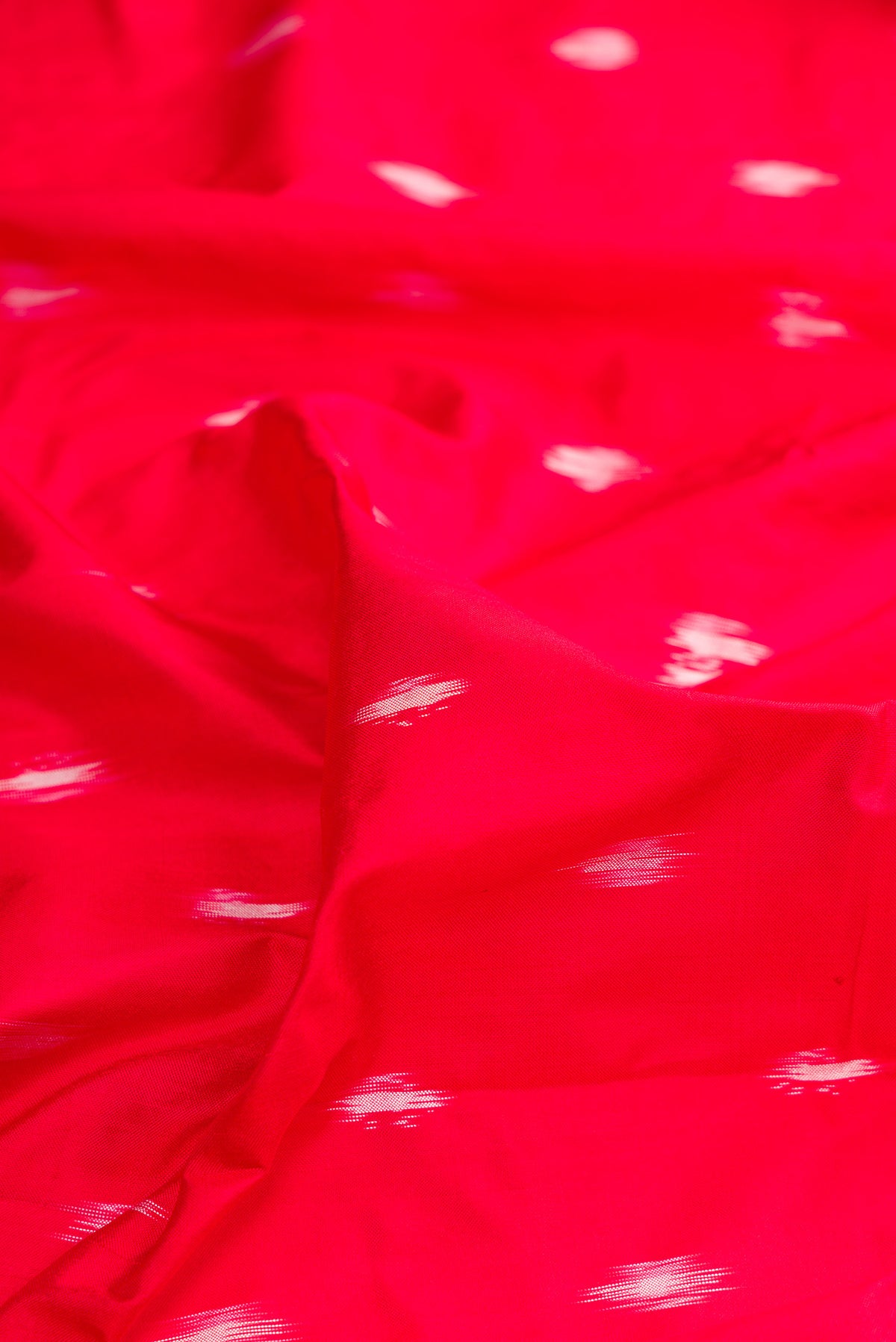 Close up of Pure Silk Red Pochampally Saree with Ikat design on the body and Ikat Border.  displaying folds