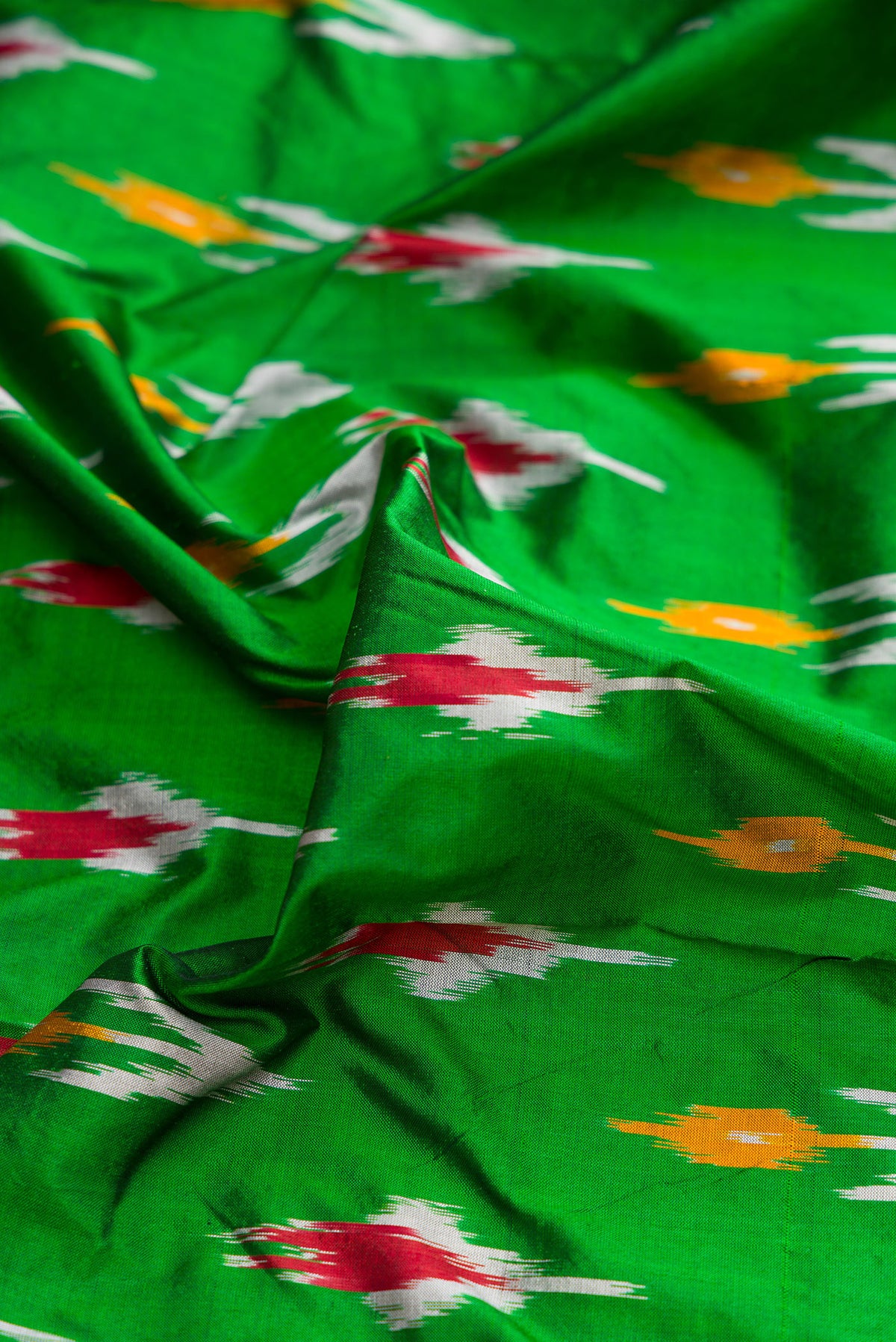Close up of Pure Silk Green Pochampally Saree with Ikat Print on the body and Ikat Border.  displaying folds