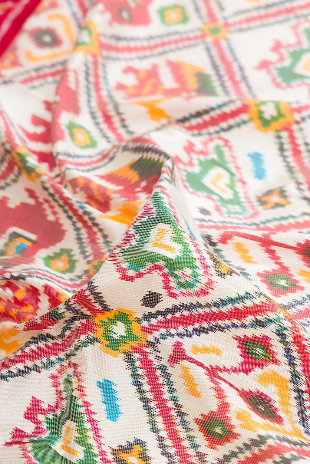 Close up of Pure Silk Off White Pochampally Saree with Pure Ikat on the body and Ikat Border.  displaying folds