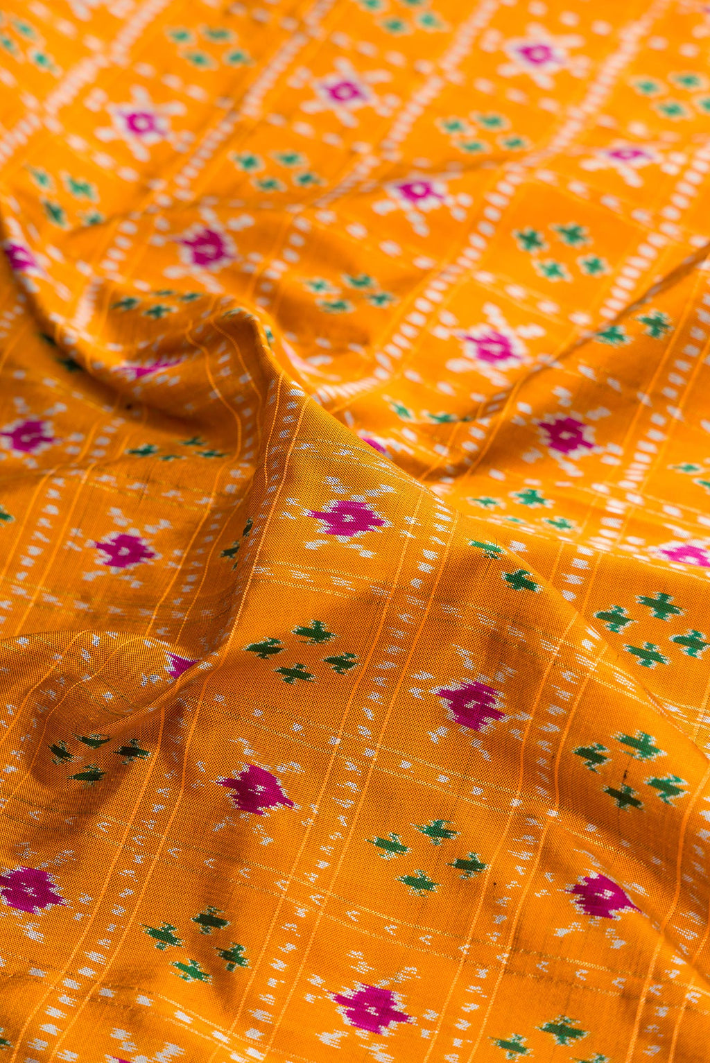 Close up of Pure Silk Mustard Pochampally Saree with Pure Ikat on the body and Ikat Border.  displaying folds