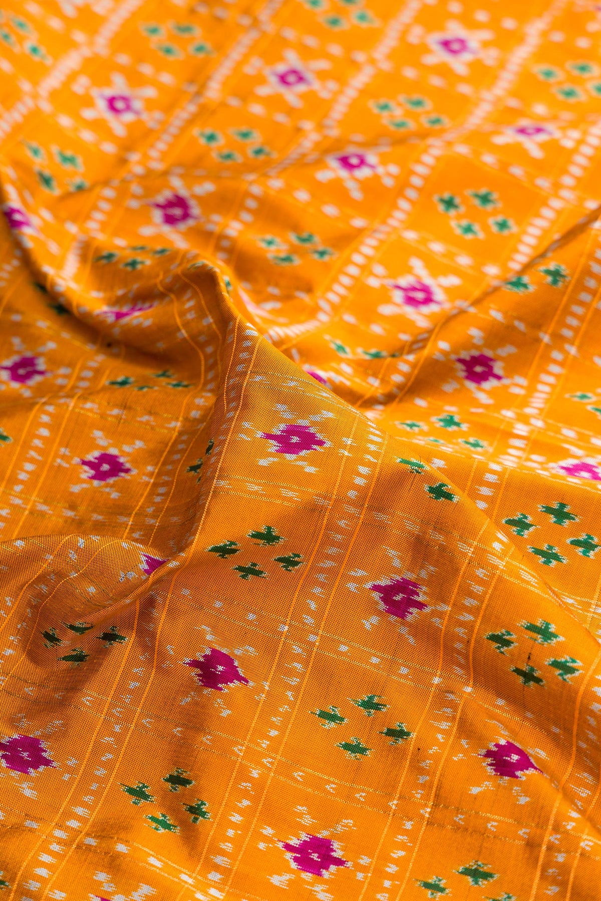 Close up of Pure Silk Mustard Pochampally Saree with Pure Ikat on the body and Ikat Border.  displaying folds