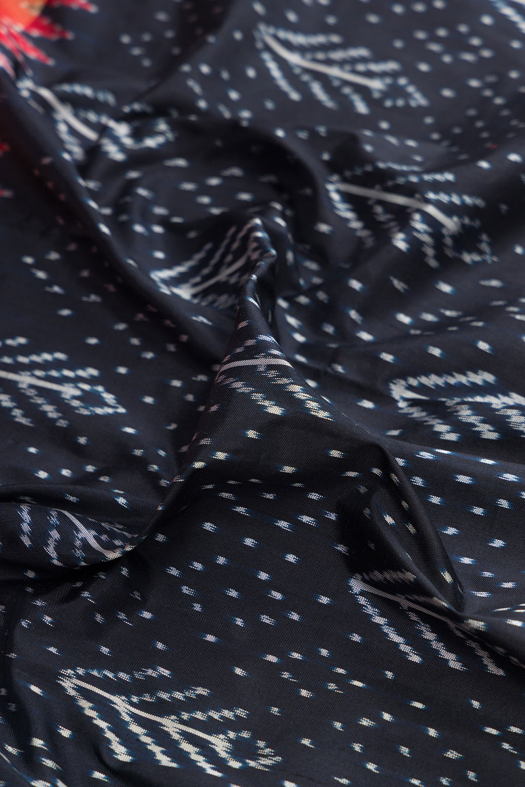 Close up of Pure Silk Navy Blue Dual Tone Double Ikat Saree with Ikat Print on the body and Ikat Border.  displaying folds