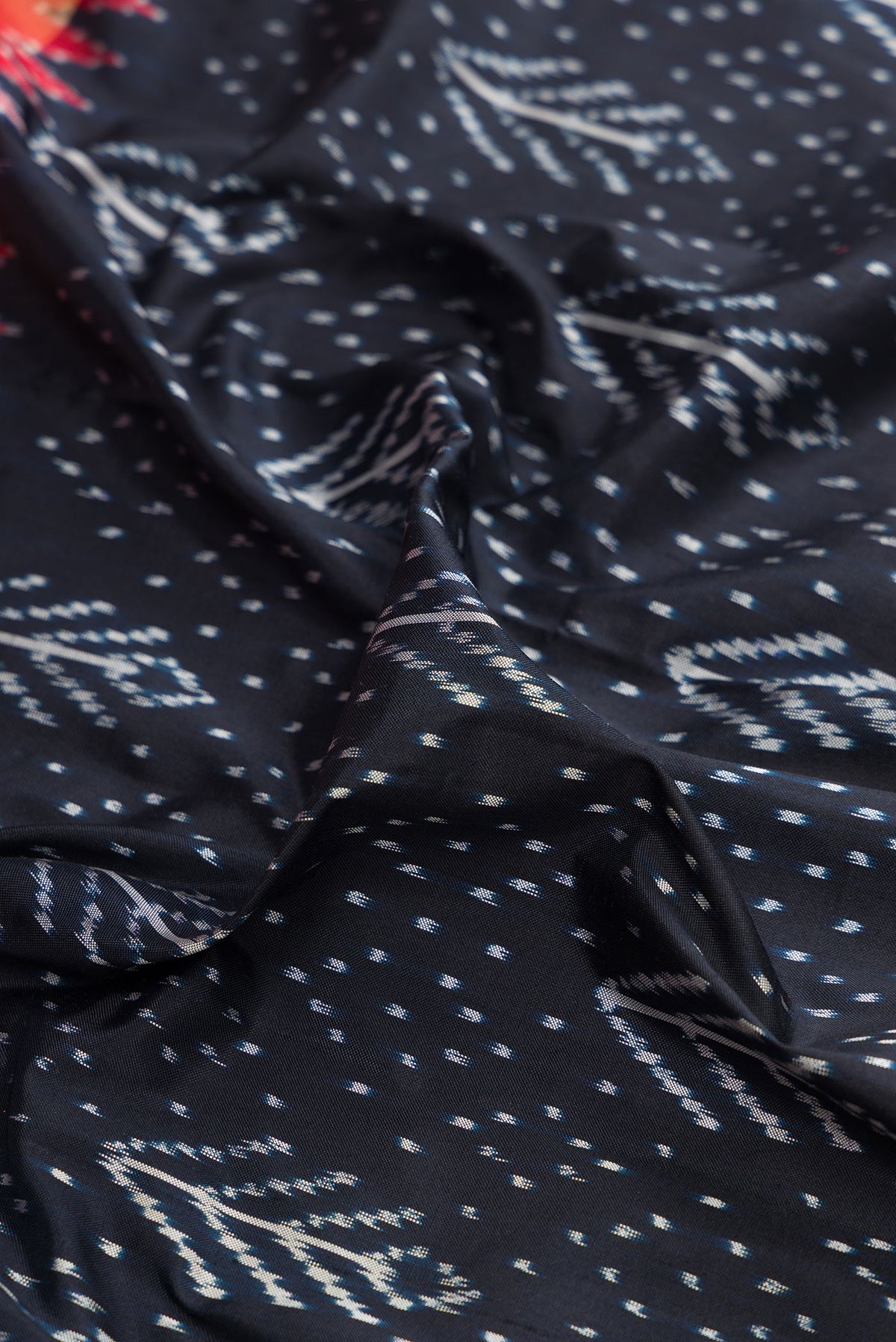 Close up of Pure Silk Navy Blue Dual Tone Double Ikat Saree with Ikat Print on the body and Ikat Border.  displaying folds