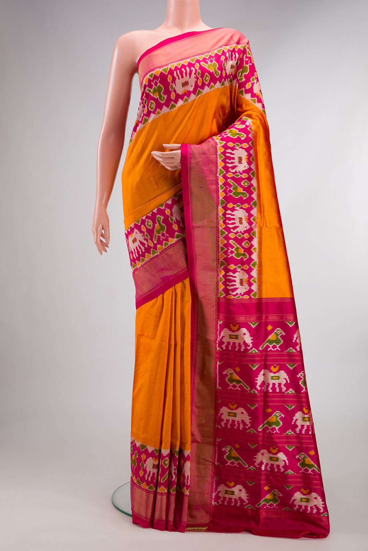 Pure Silk Orange Dual Tone Double Ikat Saree with Plain Body and Ikat Border.  displayed on a mannequin