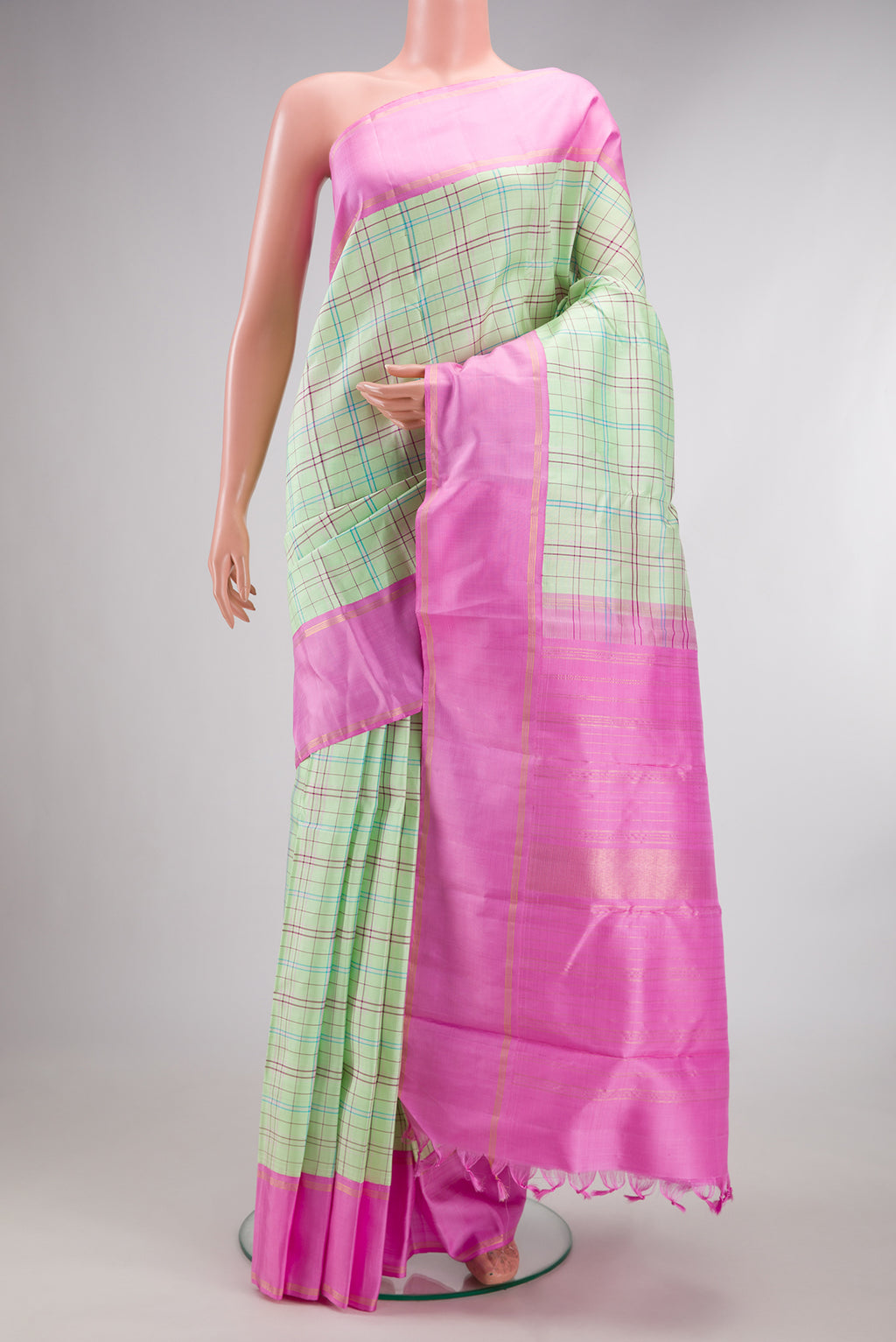 Pure Silk Pure Zari Pista Green Kanjivaram Saree with Checked design on the body and Plain Border.  displayed on a mannequin
