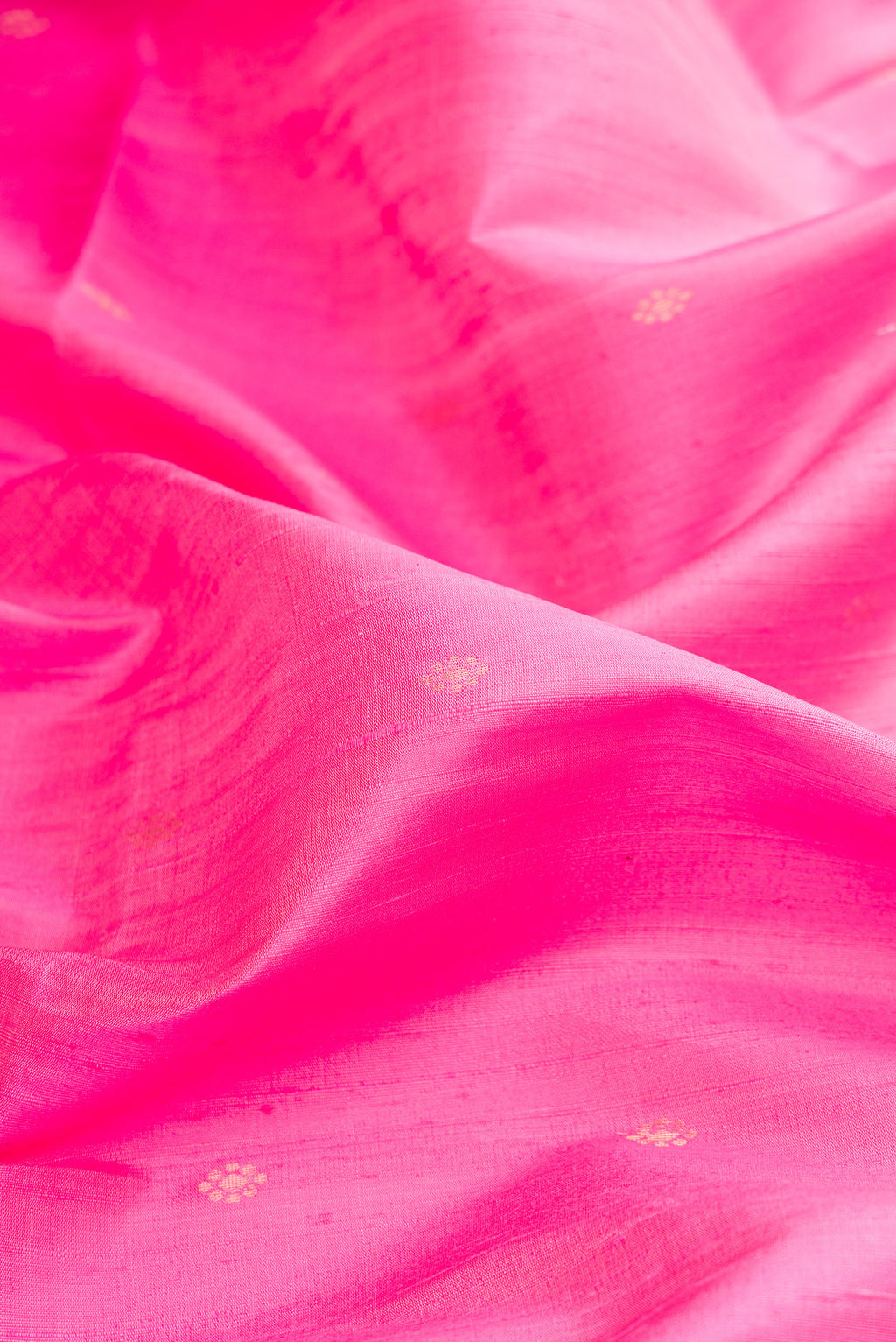 Close up of Pink Raw Saree with Zari Butta on the body and Zari Border.  displaying folds