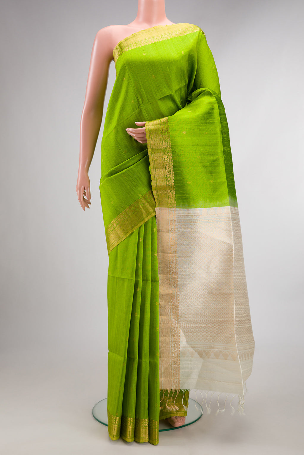 Parrot Green Raw Saree with Zari Butta on the body and Zari Border.  displayed on a mannequin