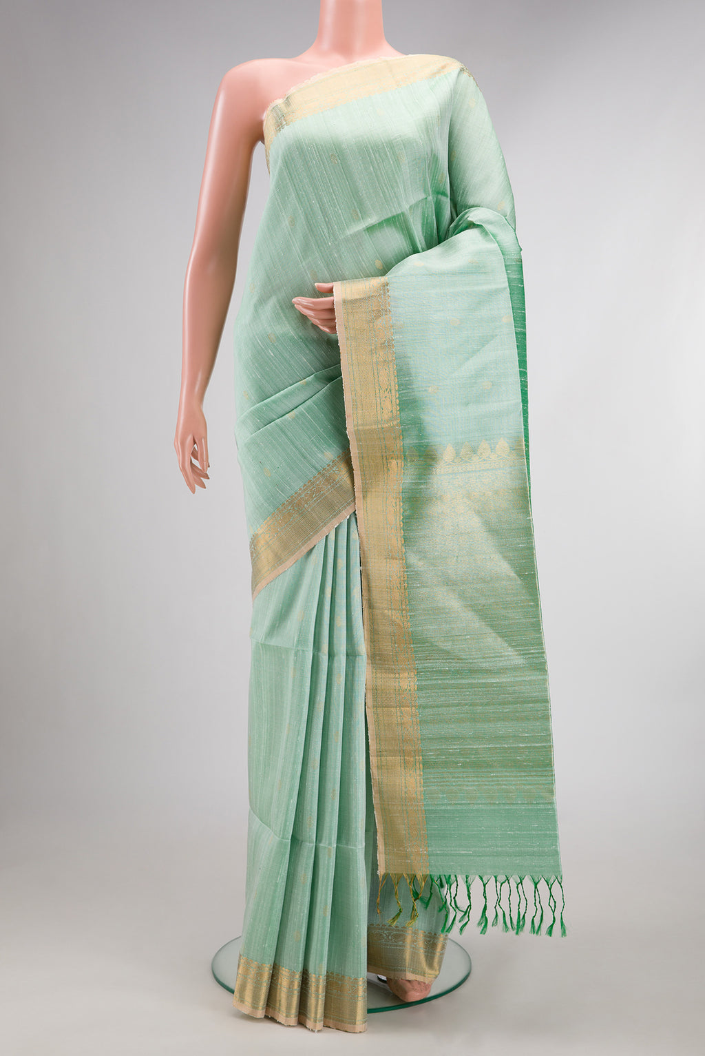 Pista Green Raw Saree with Zari Butta on the body and Zari Border.  displayed on a mannequin