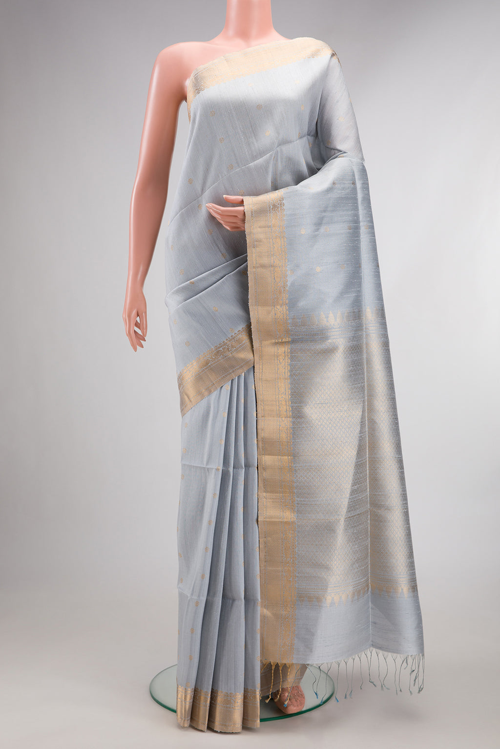 Light Blue Raw Saree with Zari Butta on the body and Zari Border.  displayed on a mannequin