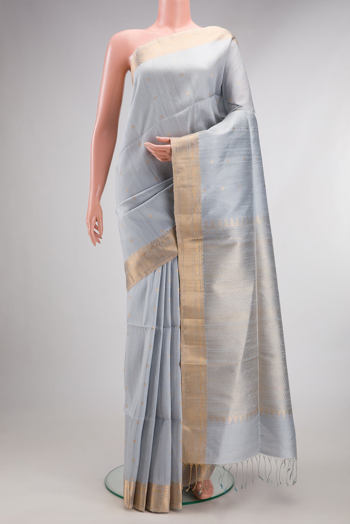 Light Blue Raw Saree with Zari Butta on the body and Zari Border.  displayed on a mannequin