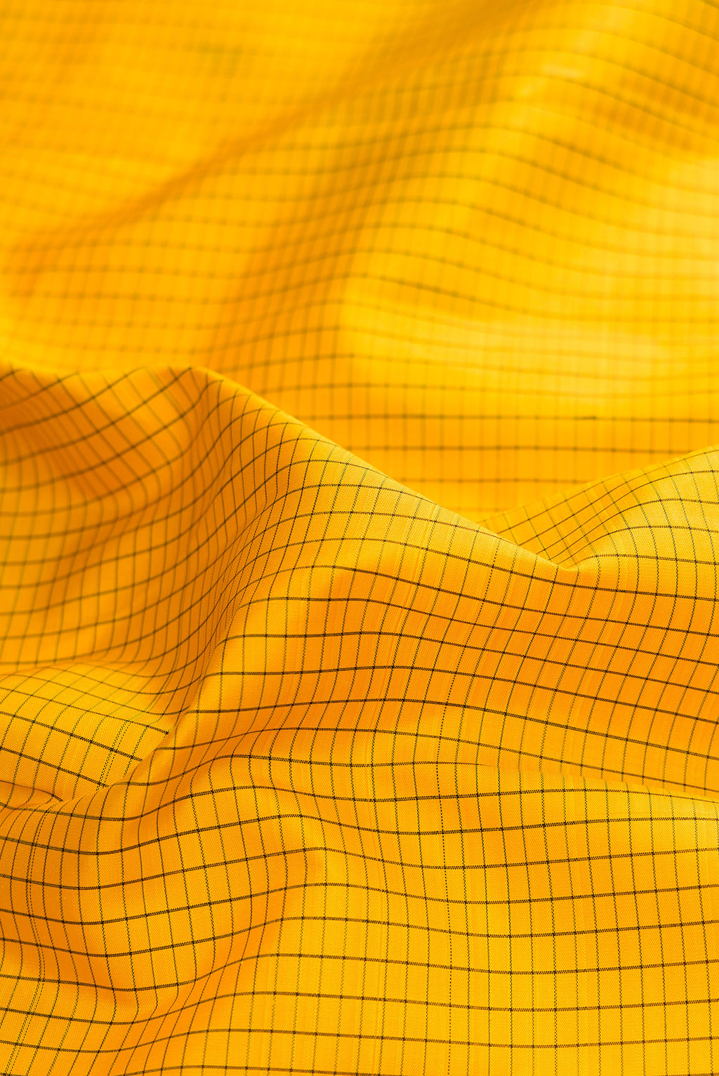 Close up of Pure Silk Yellow Kanjivaram Saree with Checked design on the body and Temple Border.  displaying folds