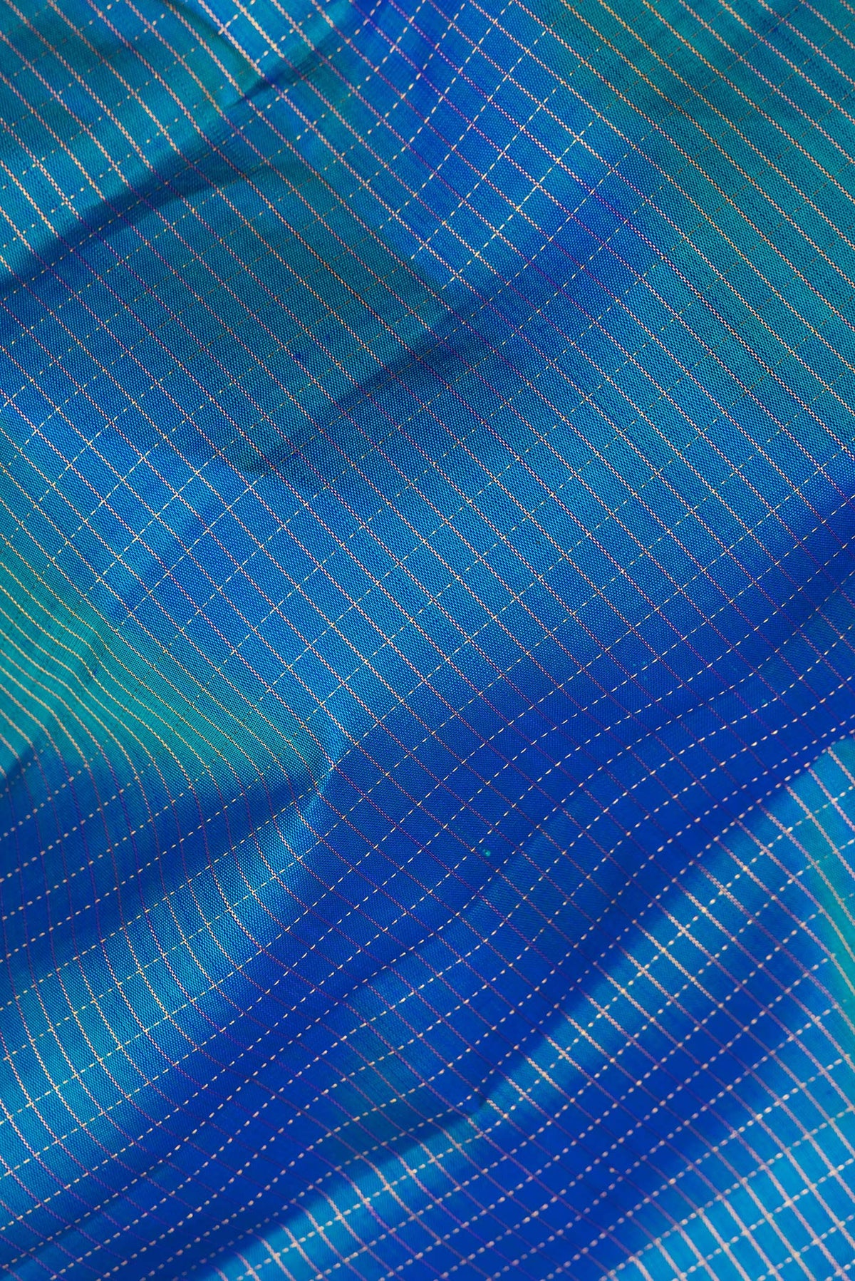 Close up of Pure Silk Peacock Blue Kanjivaram Saree with Checked design on the body and Fancy Border.  displaying folds